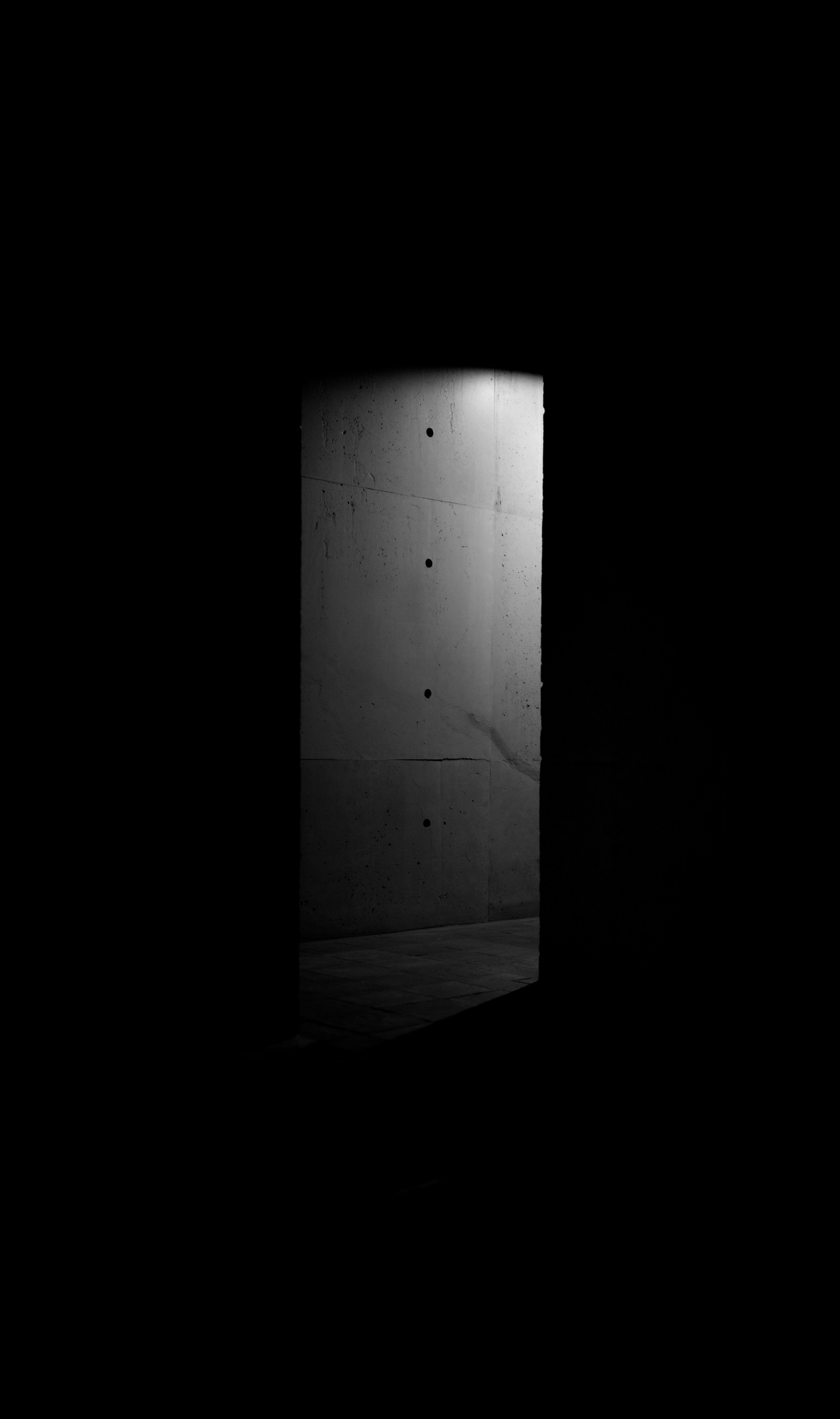 A silhouette of a bright door against a dark background