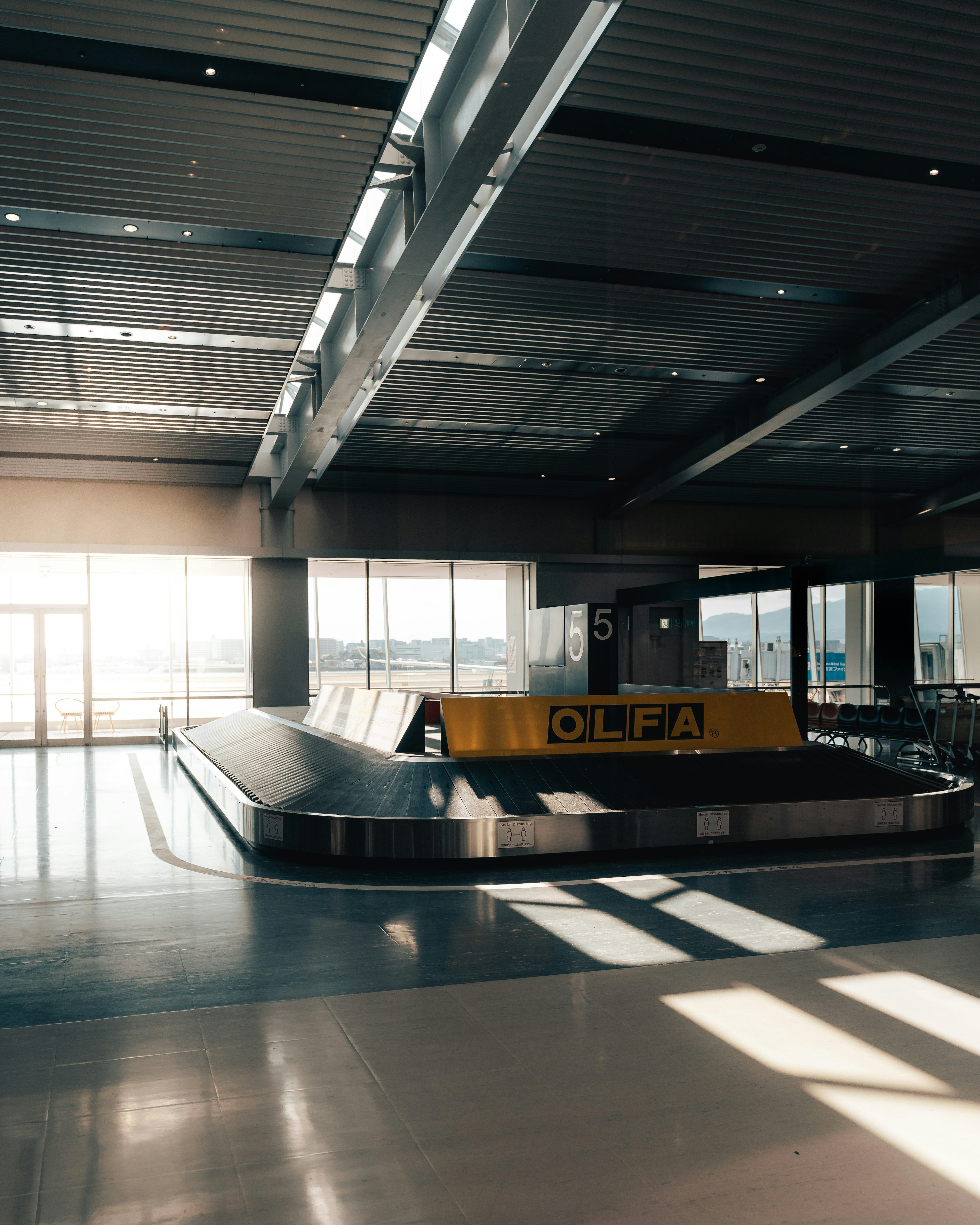 Area di ritiro bagagli tranquilla in aeroporto con luce solare che entra