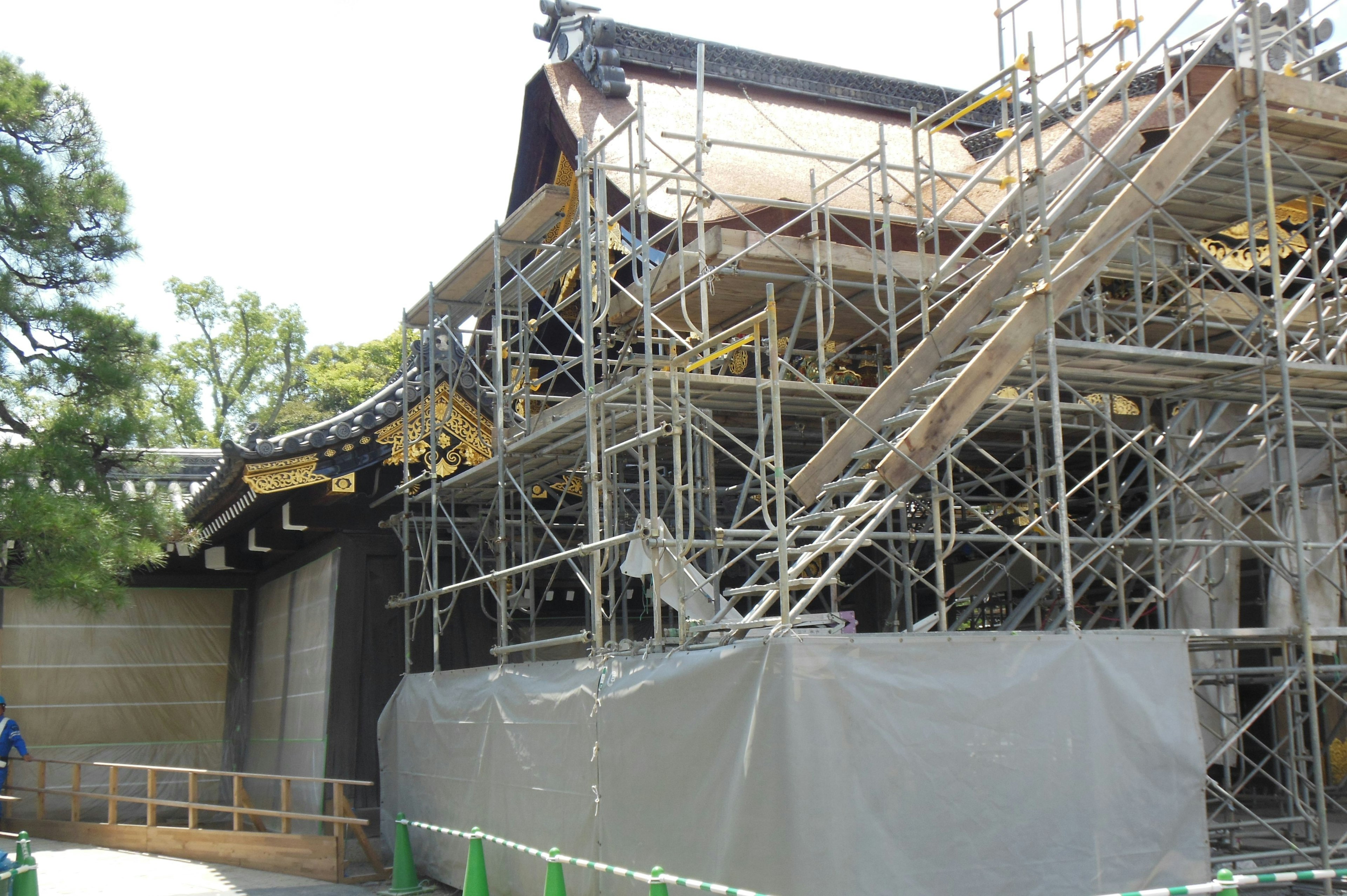 View of a building under renovation with scaffolding and protective covering