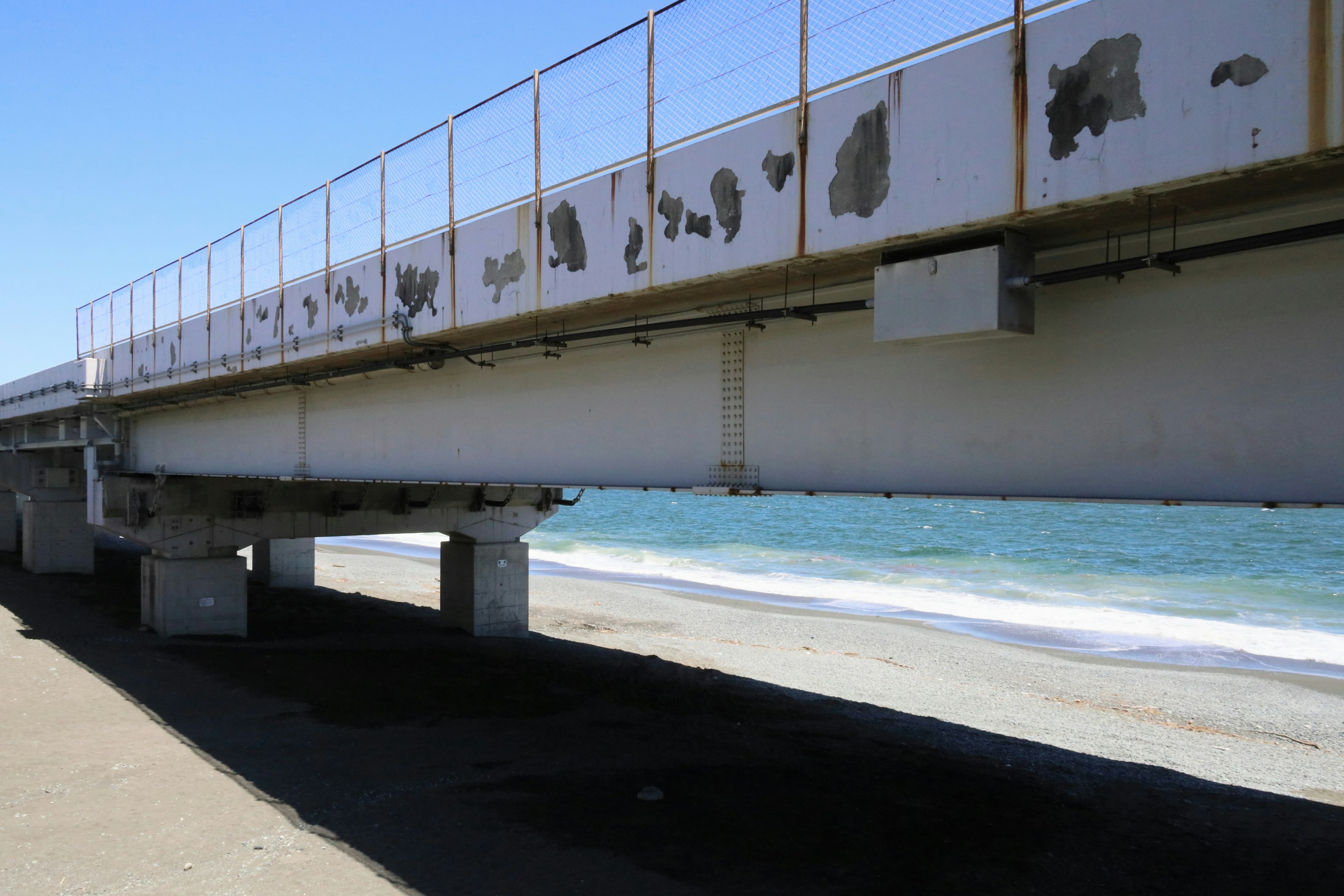 Debajo de un viejo puente sobre el mar con olas visibles