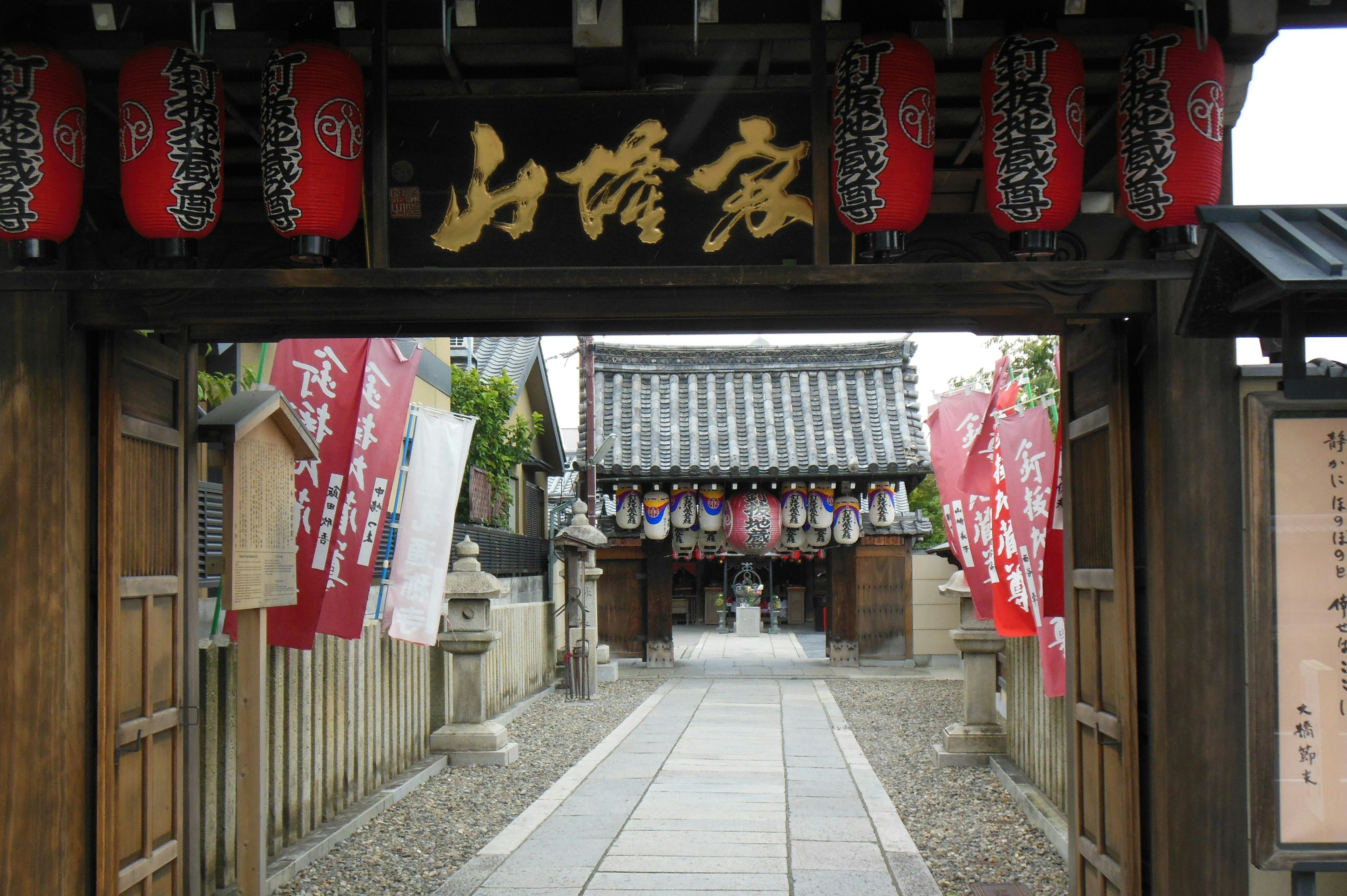 Puerta tradicional con linternas rojas en la entrada de un templo