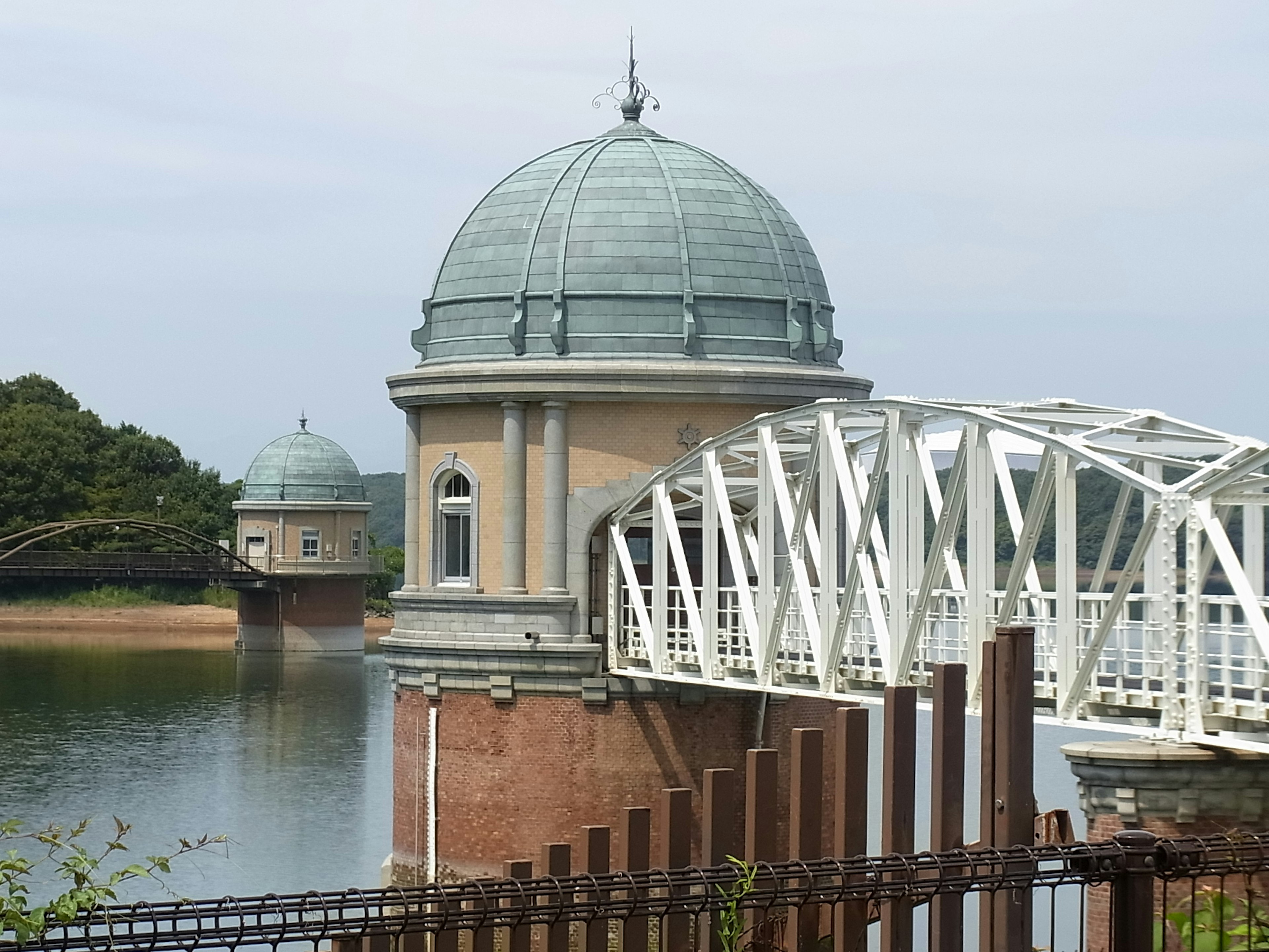 Une scène pittoresque avec un bâtiment en forme de dôme et un pont blanc au bord de l'eau