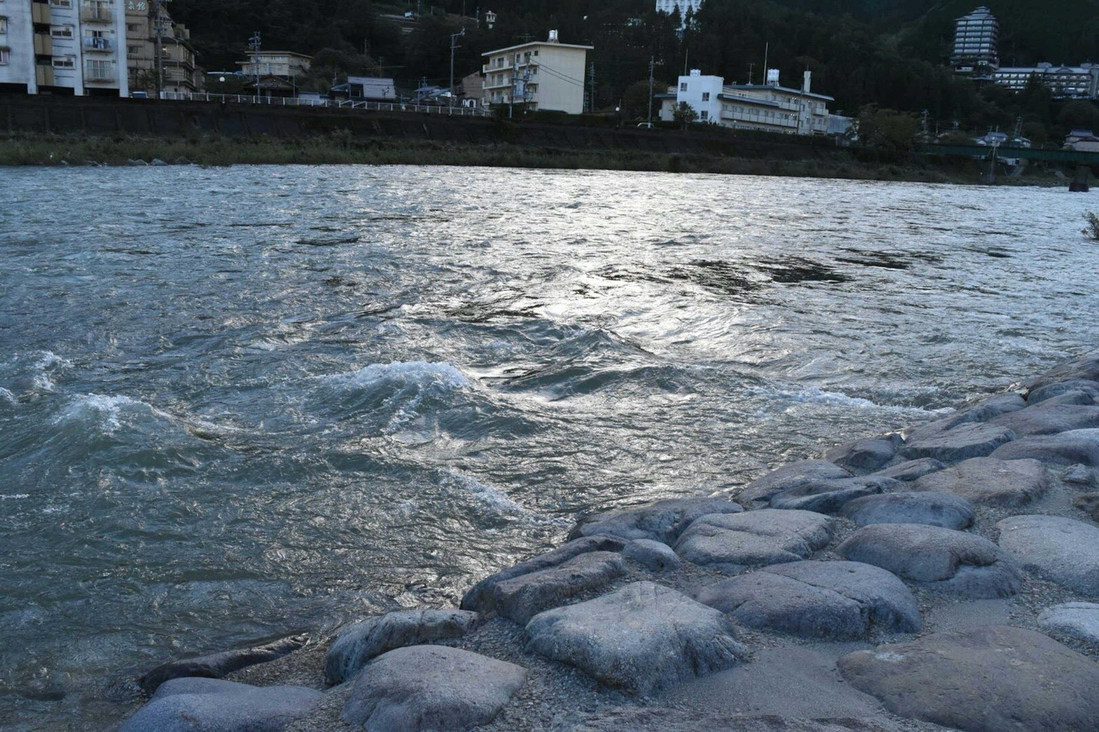 Vista escénica de un río con agua fluyendo y un dique de piedra