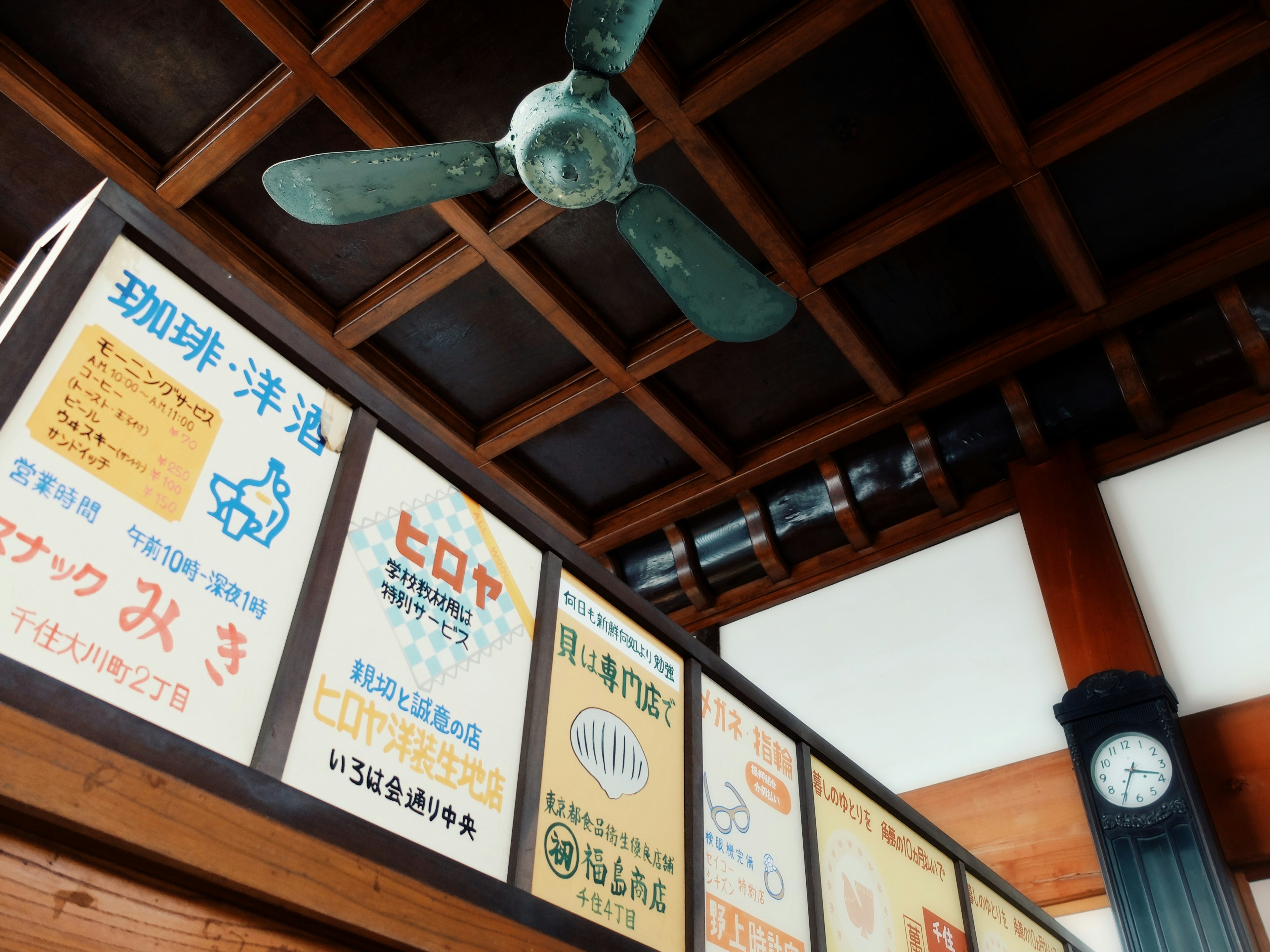 Intérieur d'un magasin japonais avec un plafond en bois et un ventilateur vintage avec des publicités colorées sur les murs