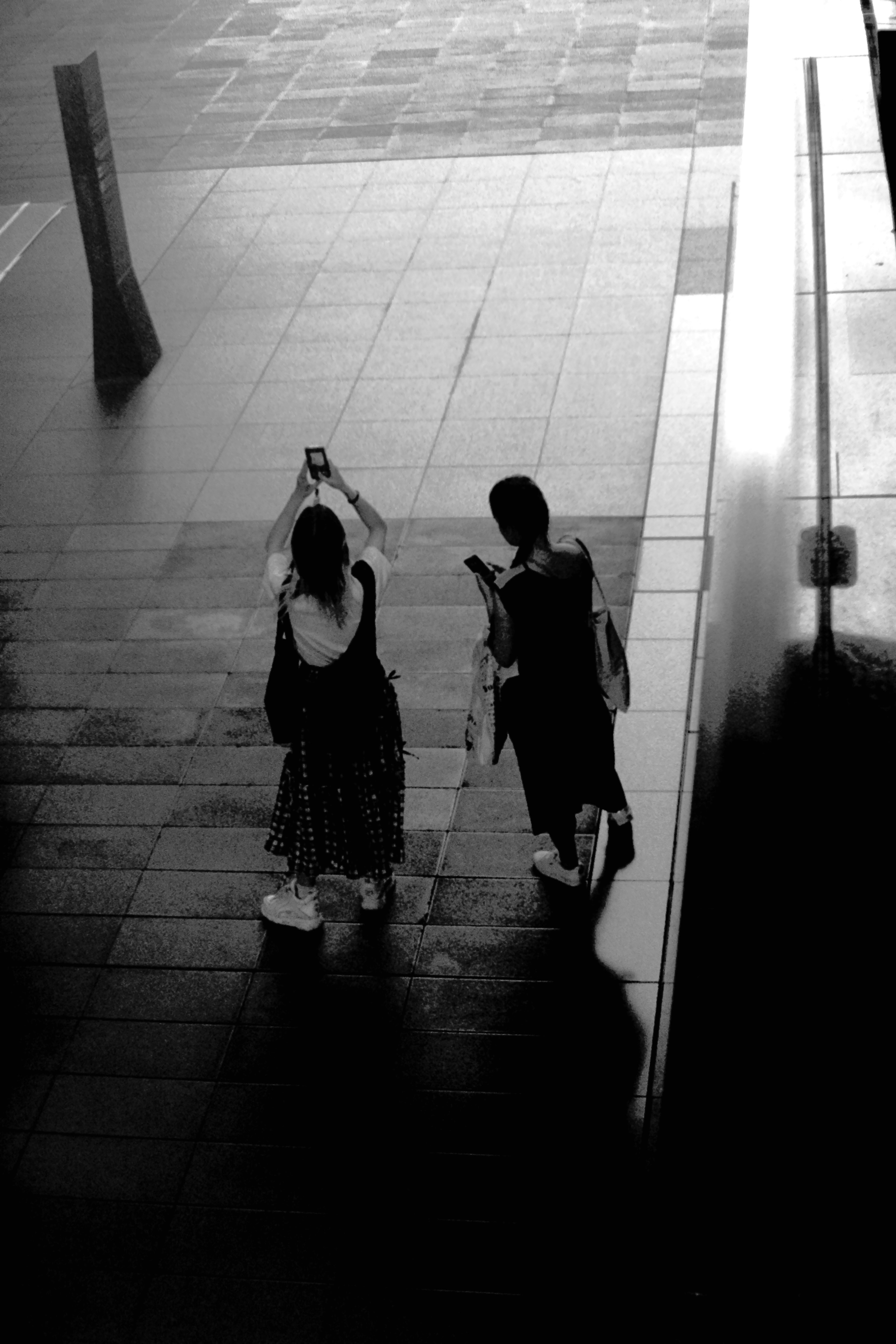 Image en noir et blanc de deux femmes marchant ensemble