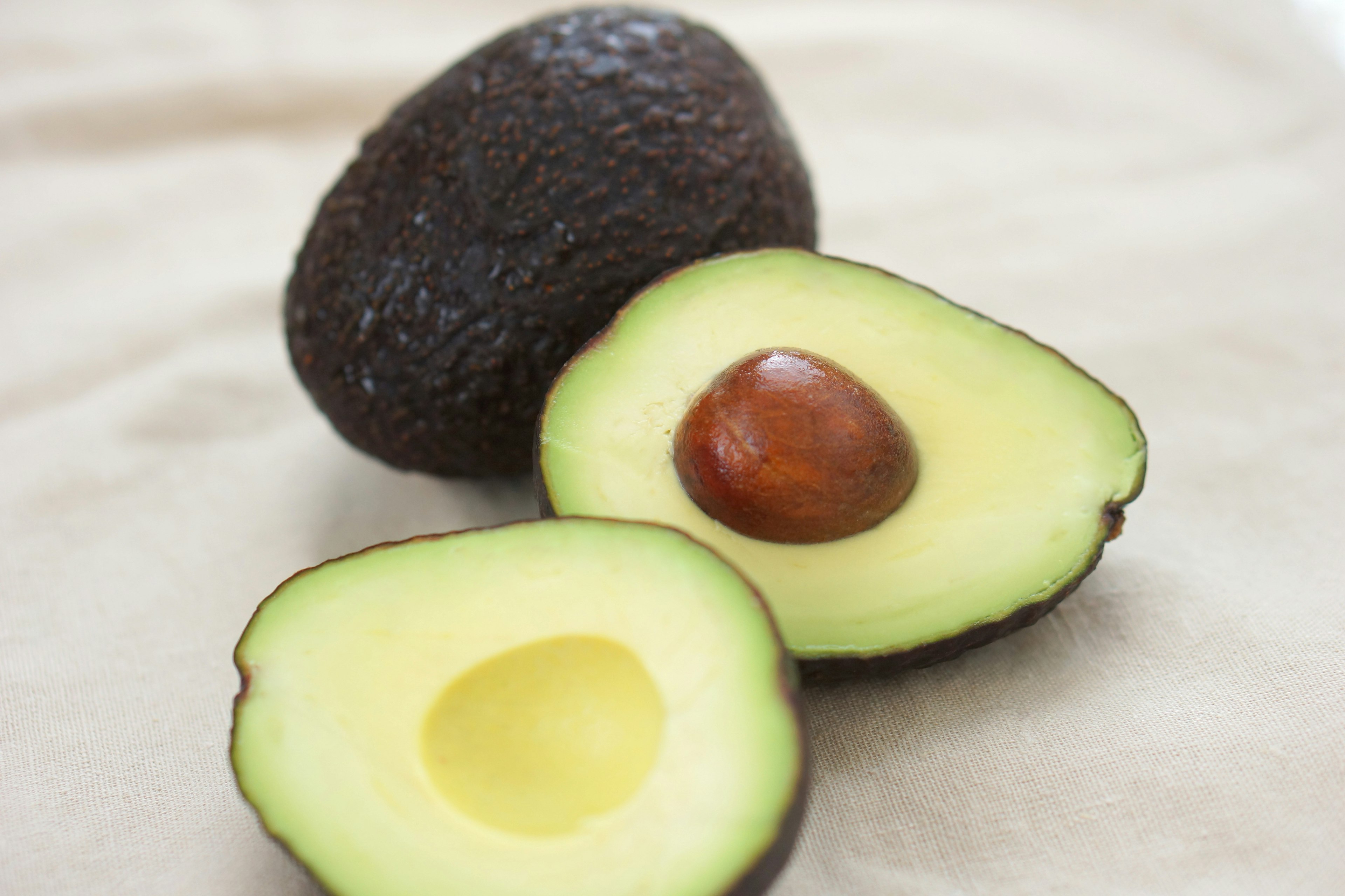 Ein lebendiges Bild, das eine ganze Avocado und ihre halbierte Version zeigt