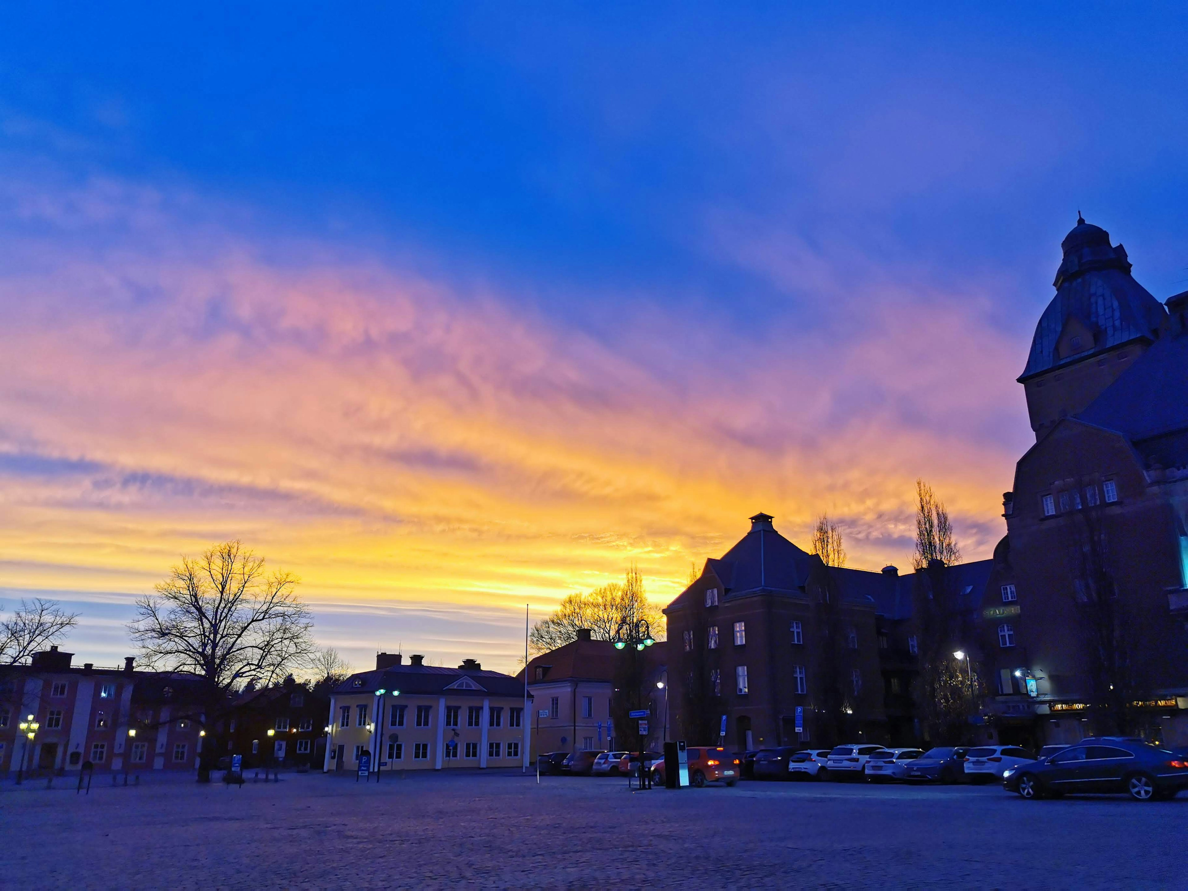 Silhouetted buildings against a vibrant sunset sky