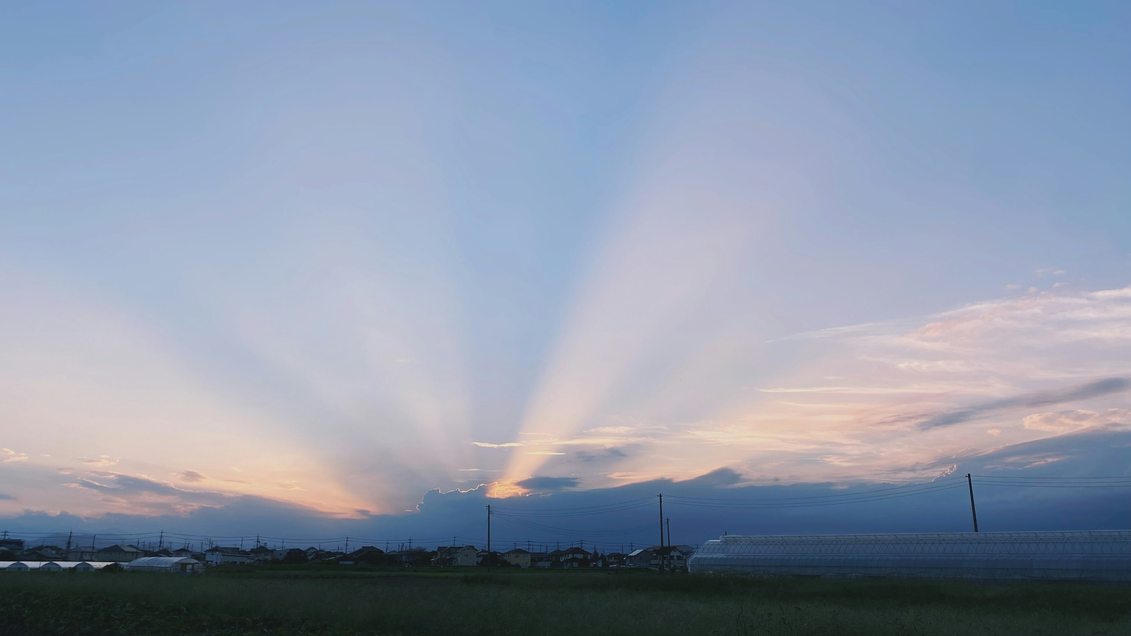 美しい空の風景、夕焼けの光線が雲から放射状に広がる