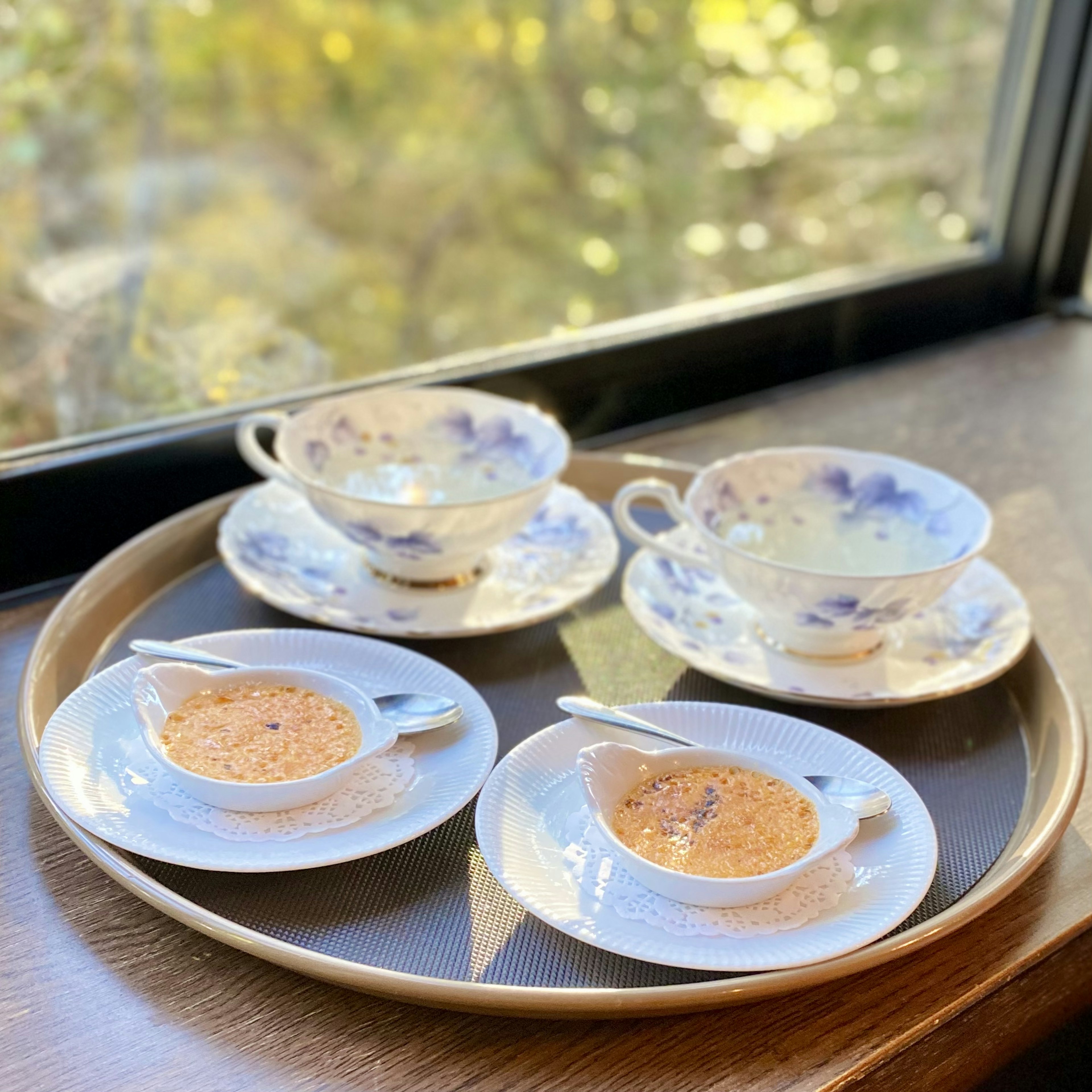 Una bandeja con tazas de té y platos de flores azules dispuestos elegantemente