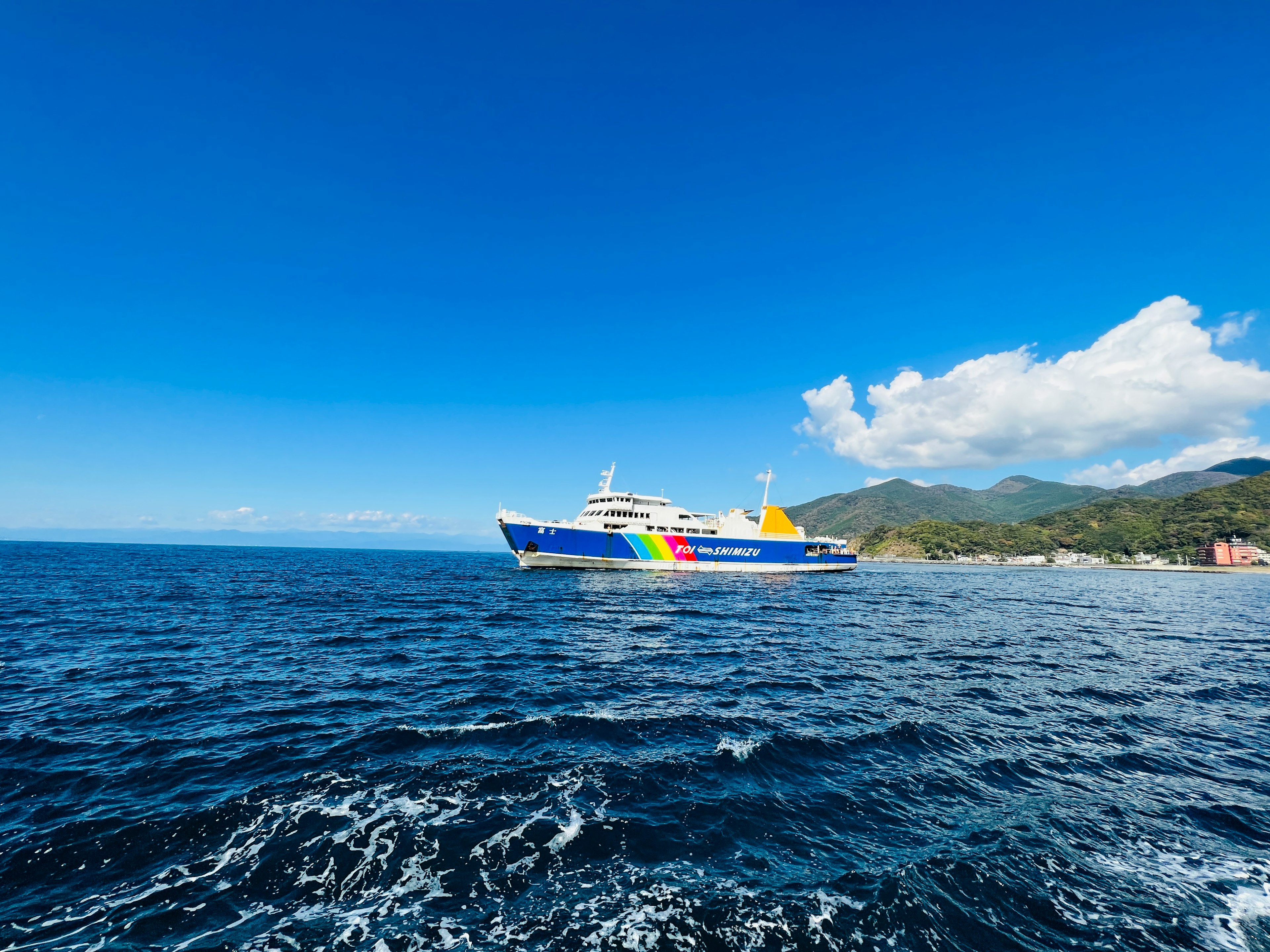 Ferry colorato ancorato su un mare blu sotto un cielo sereno