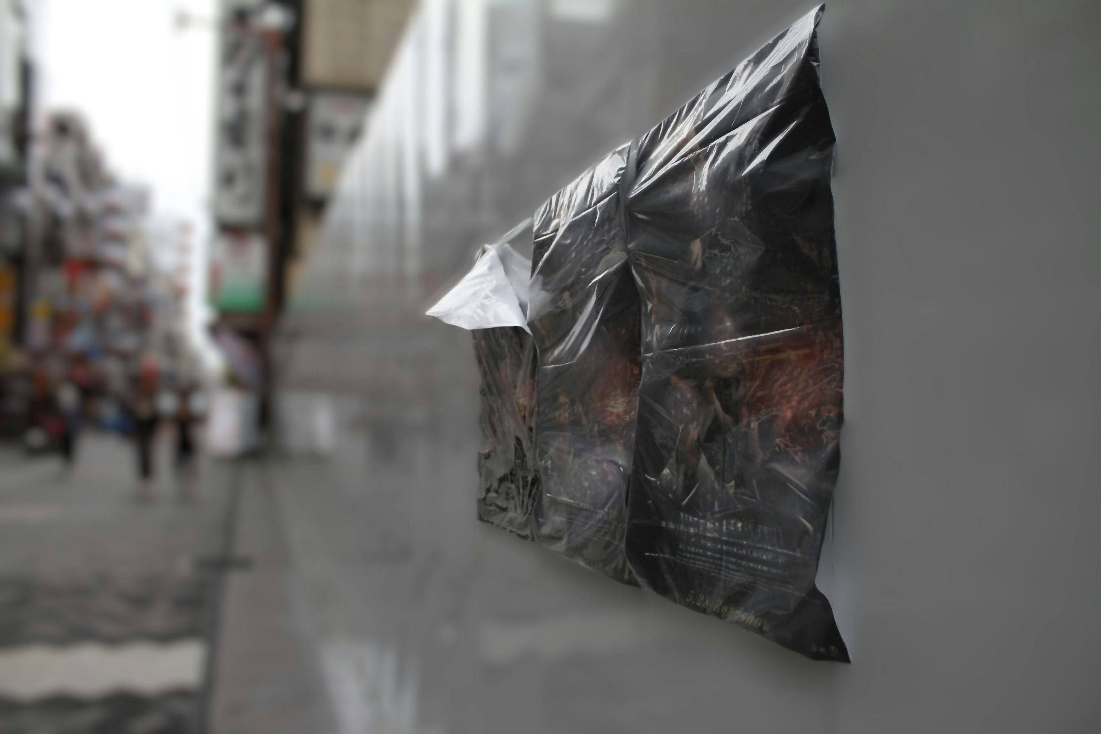 A transparent plastic bag attached to a wall in an urban setting