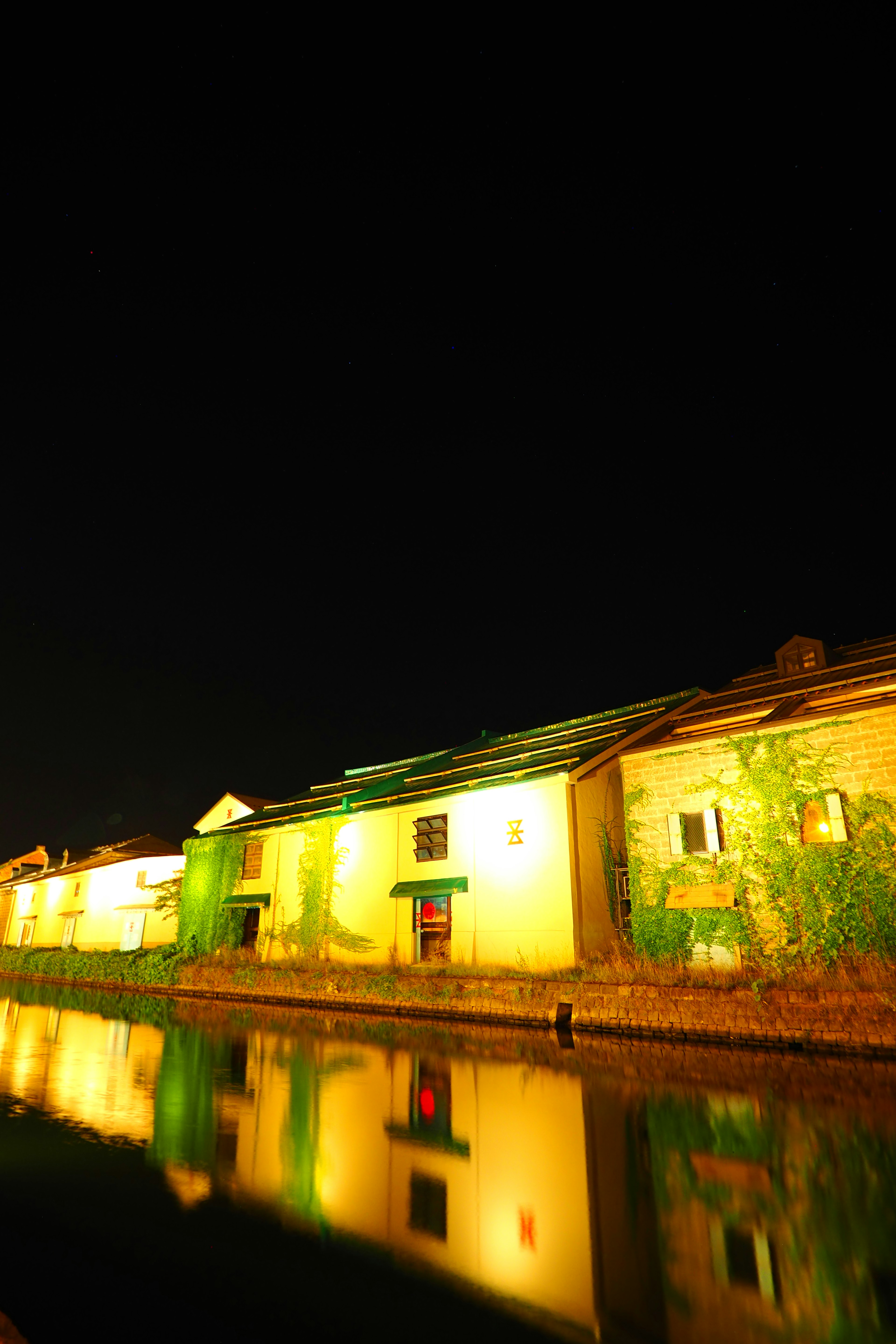 Alte Gebäude bei Nacht am Fluss beleuchtet