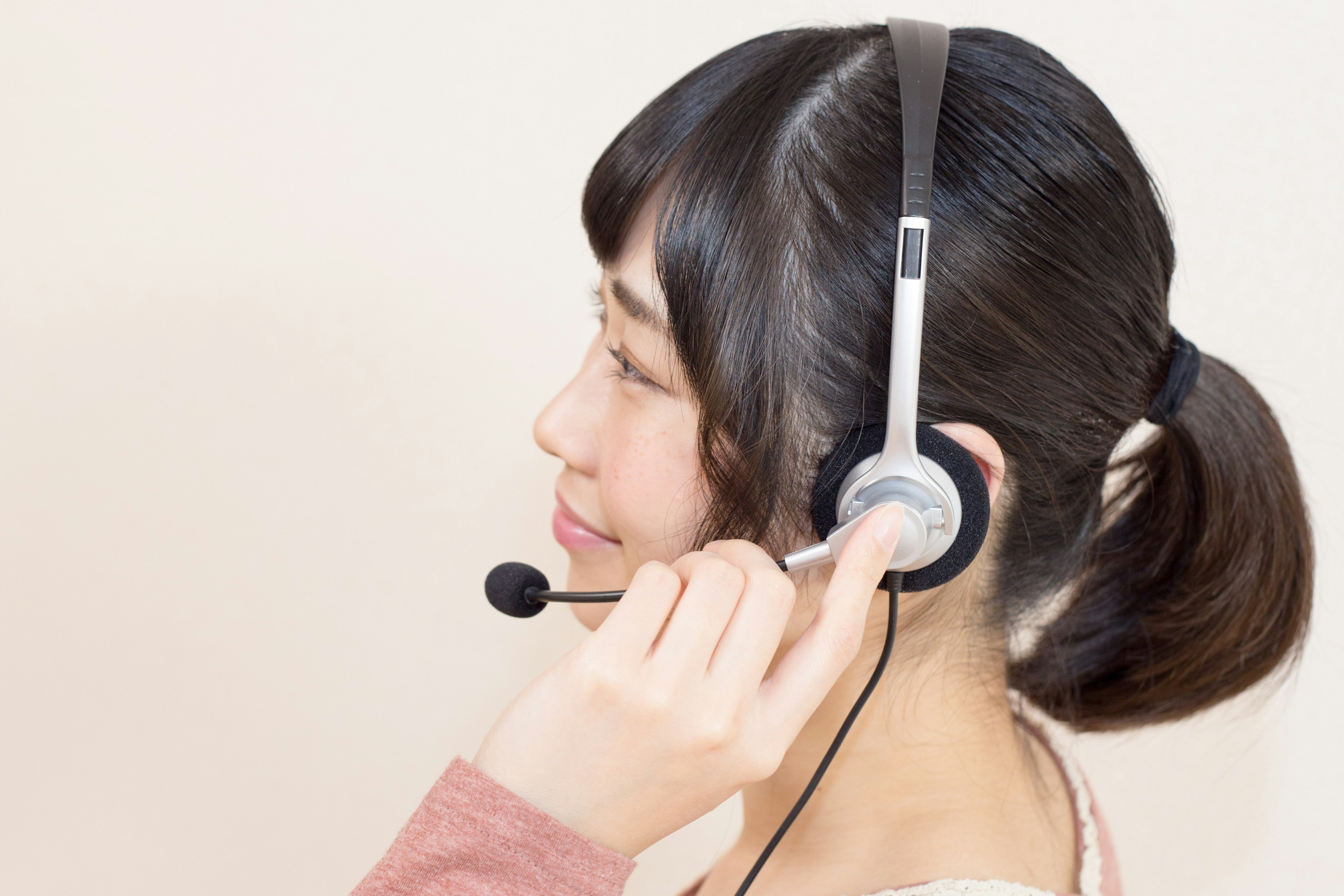 A woman smiling while wearing a headset