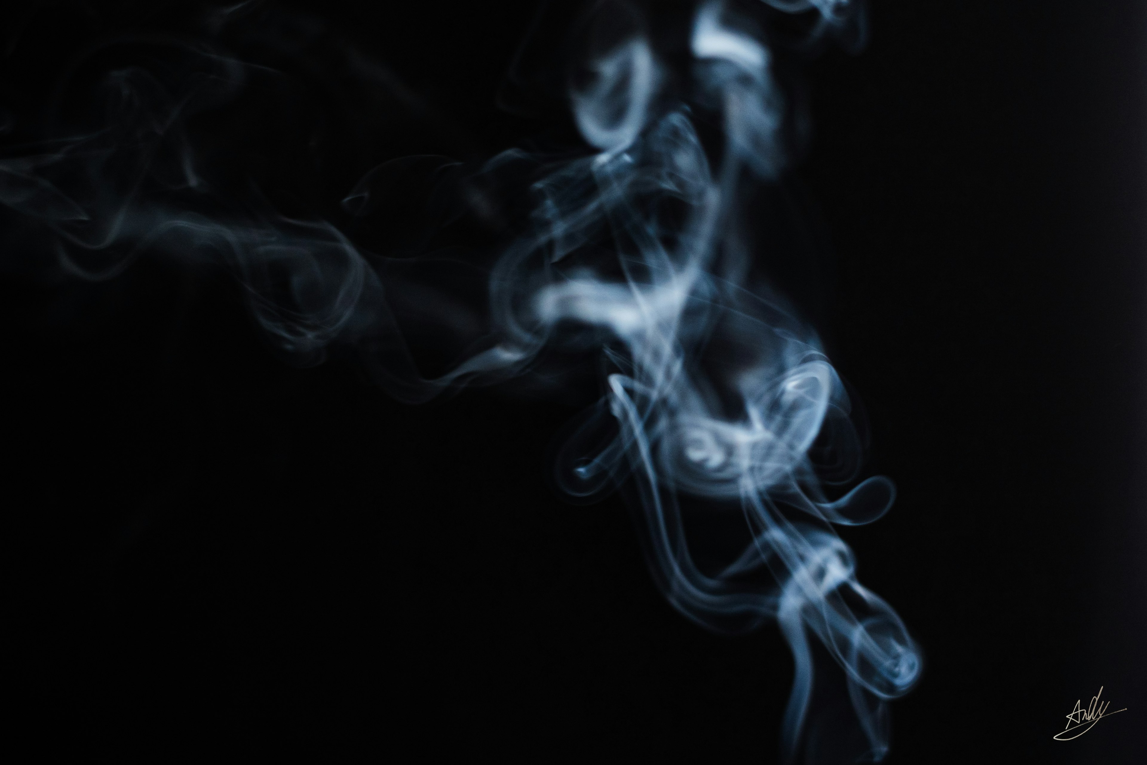 Blue smoke swirling against a black background