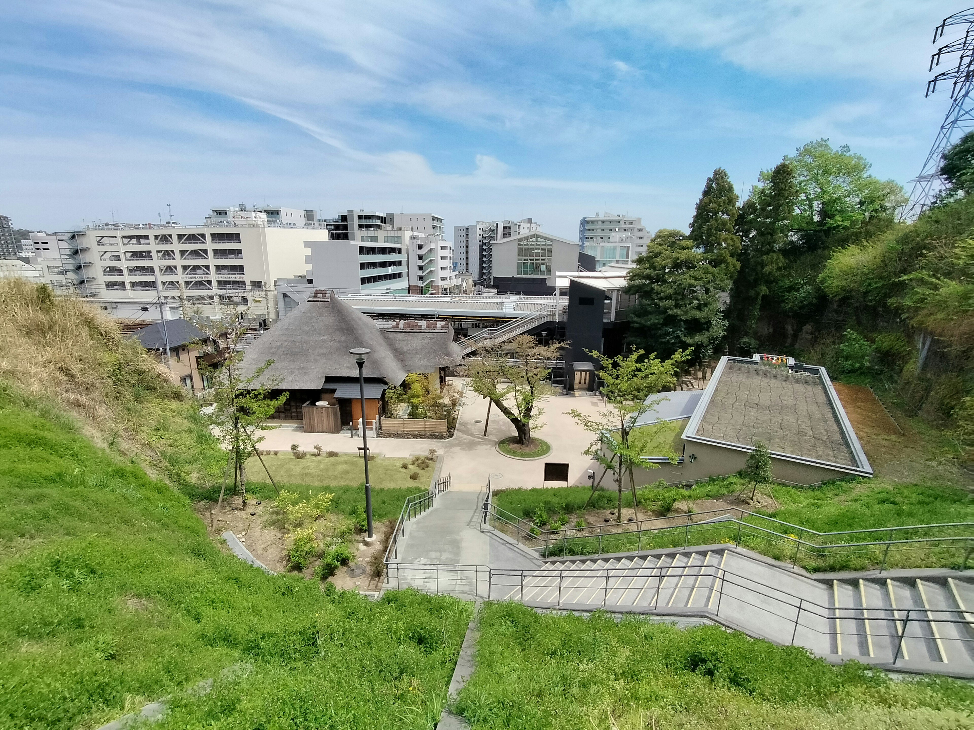 緑の丘の上から見た公園の景色 近代的な建物と伝統的な建物が混在する