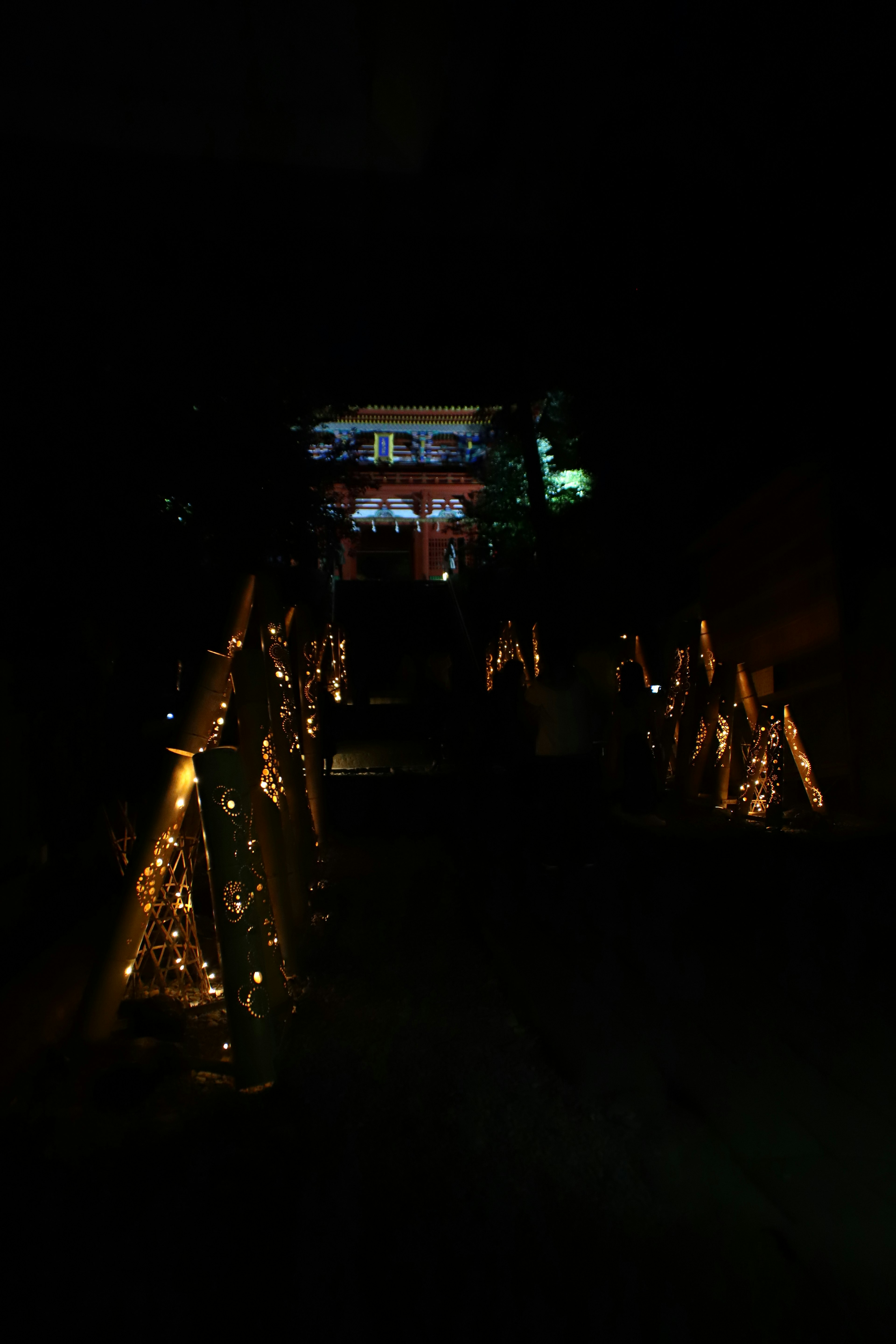 Escaliers illuminés la nuit menant à un bâtiment en arrière-plan