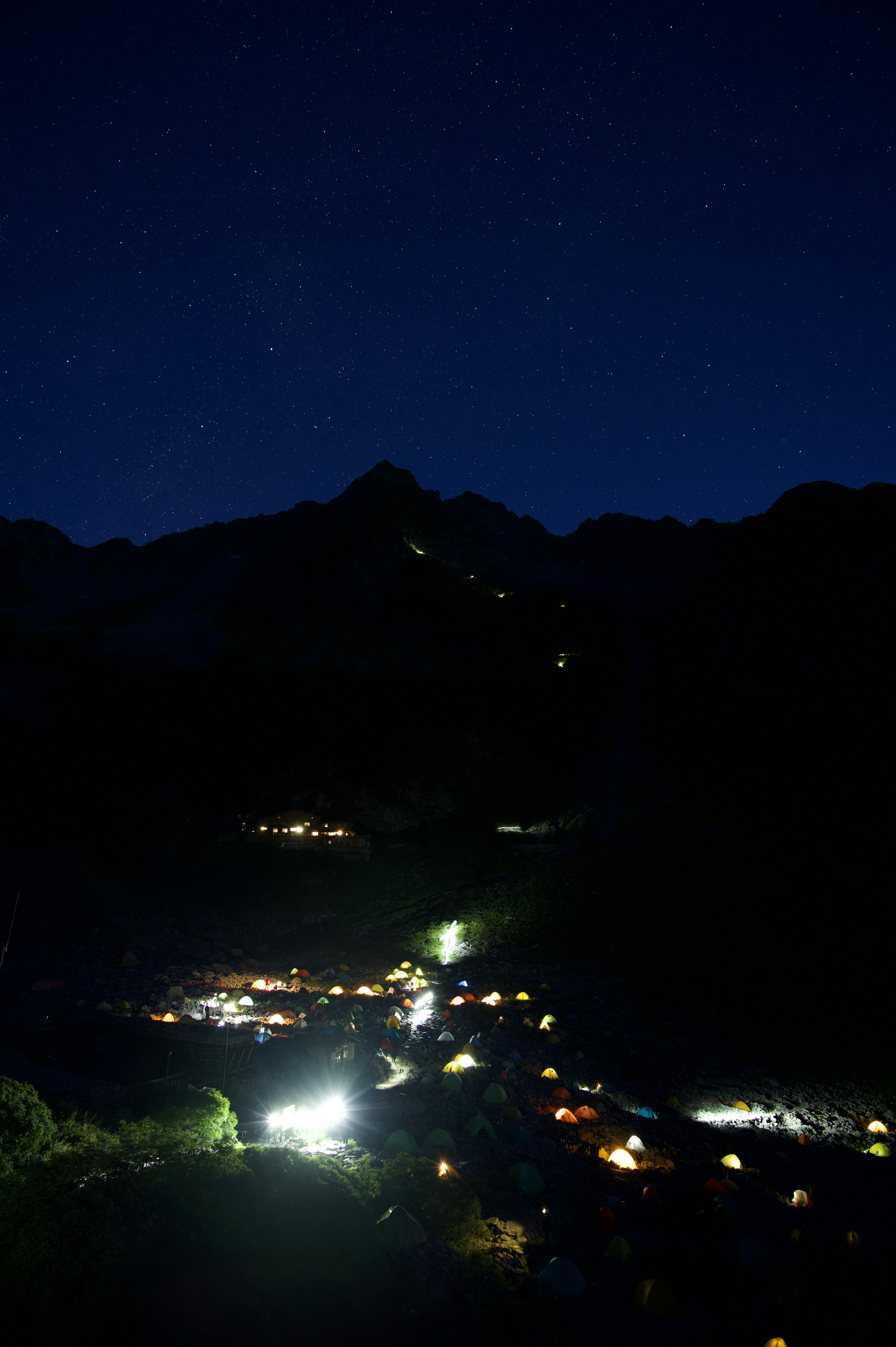 夜空に星が輝く山の風景と明かりが点在する村