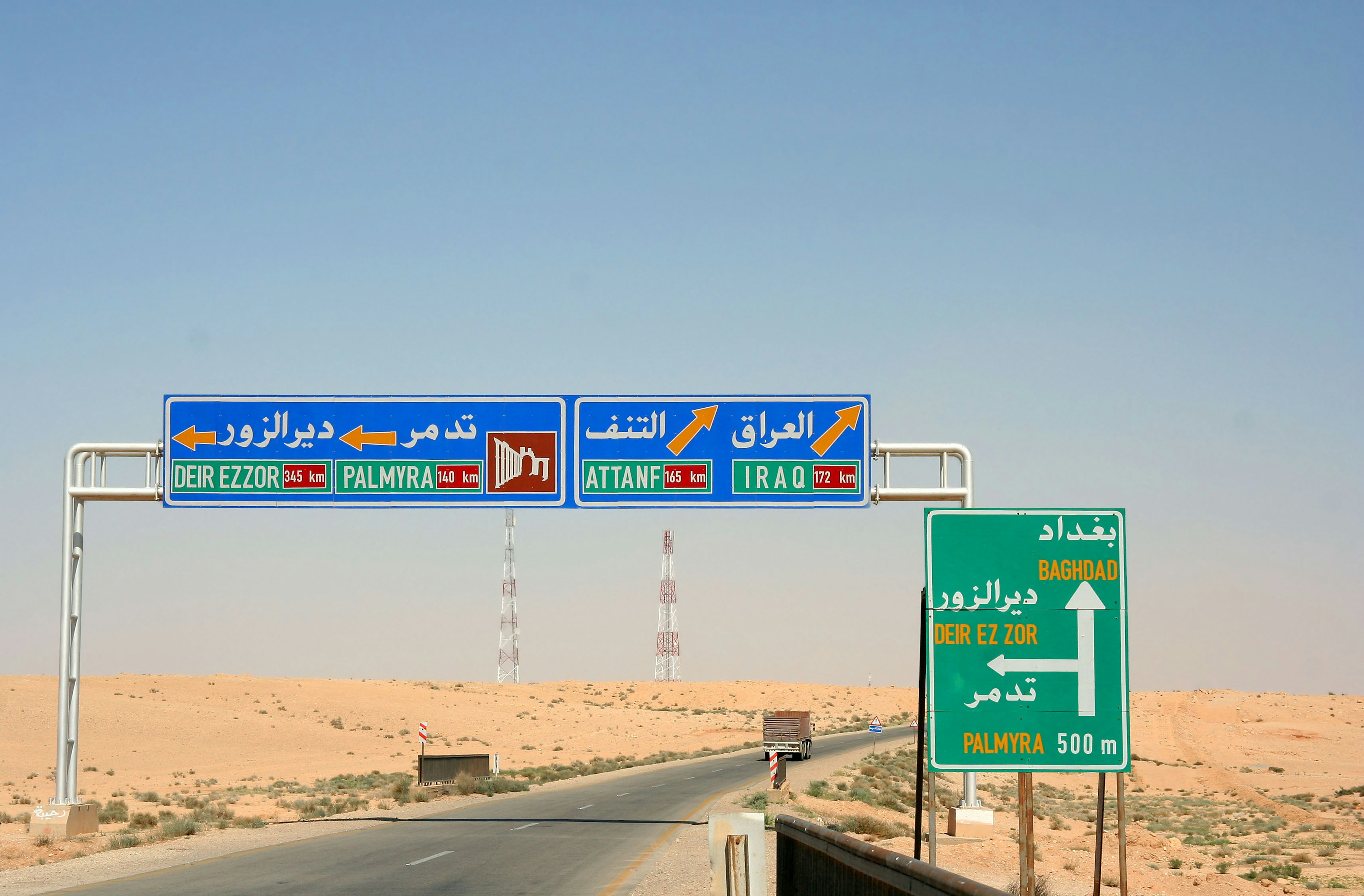 Road signs in a desert landscape with directional information