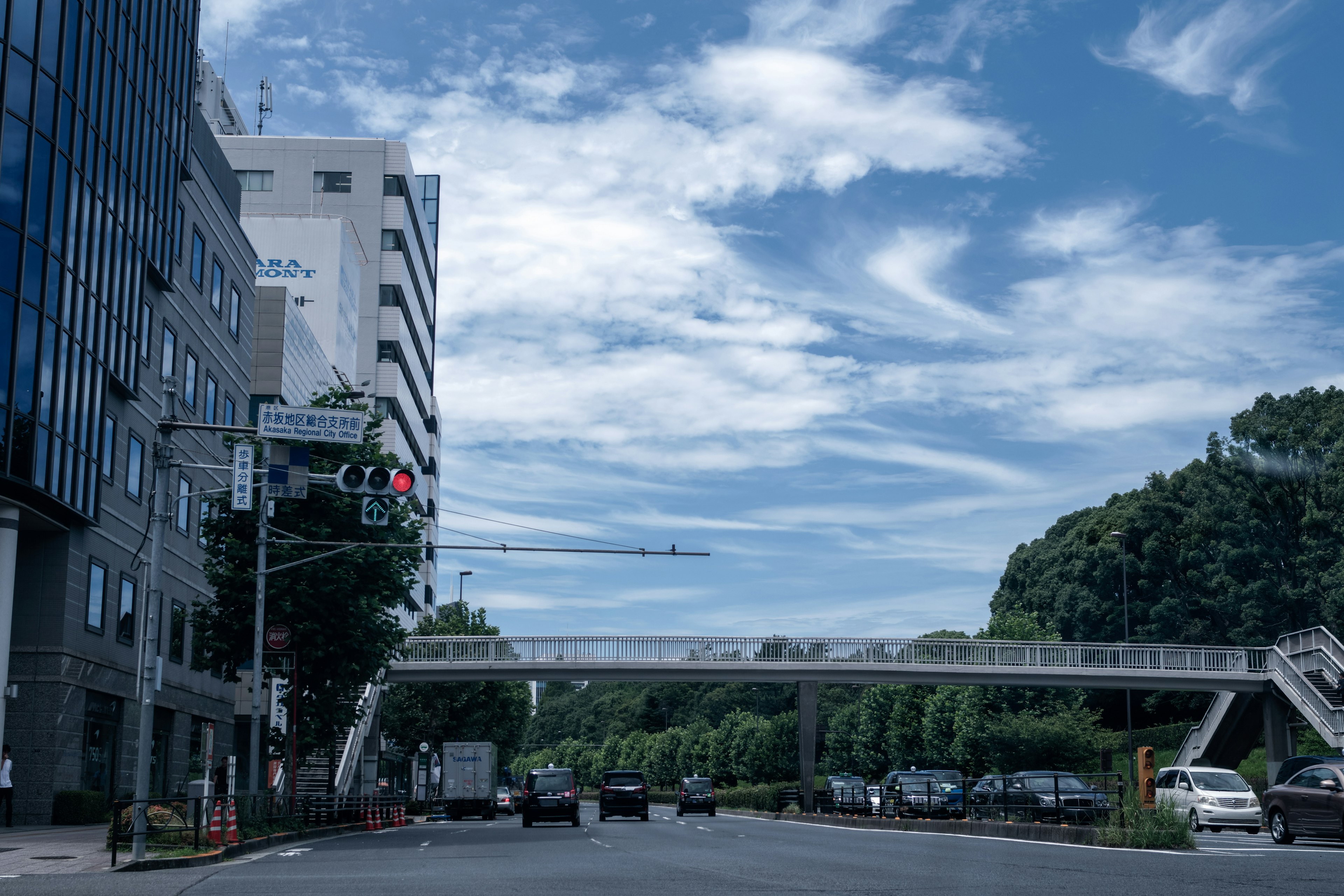 ทิวทัศน์เมืองที่มีท้องฟ้าสีฟ้าและเมฆมีถนนและสะพานคนเดิน