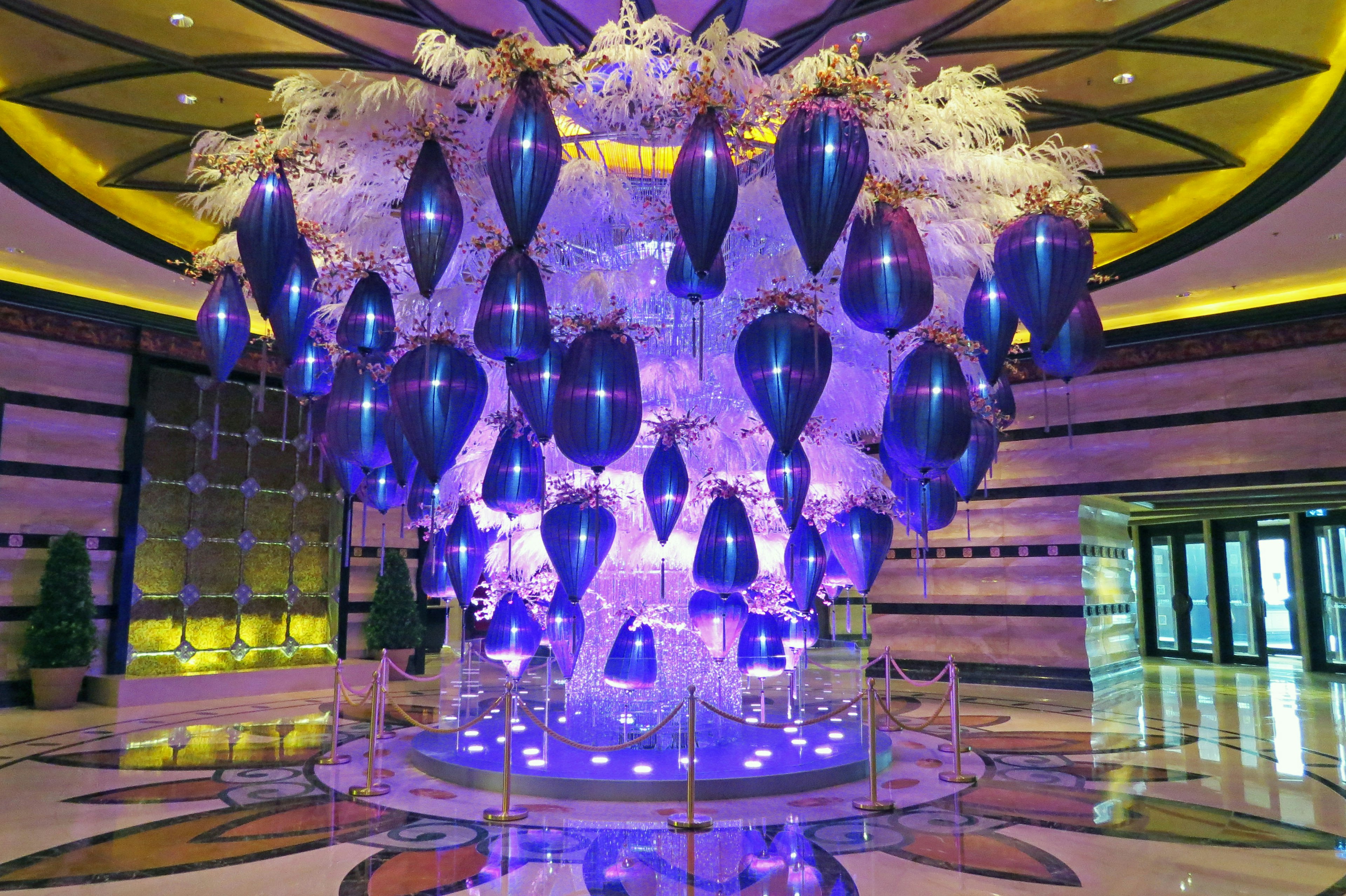 A stunning purple chandelier suspended from the ceiling in an opulent lobby setting