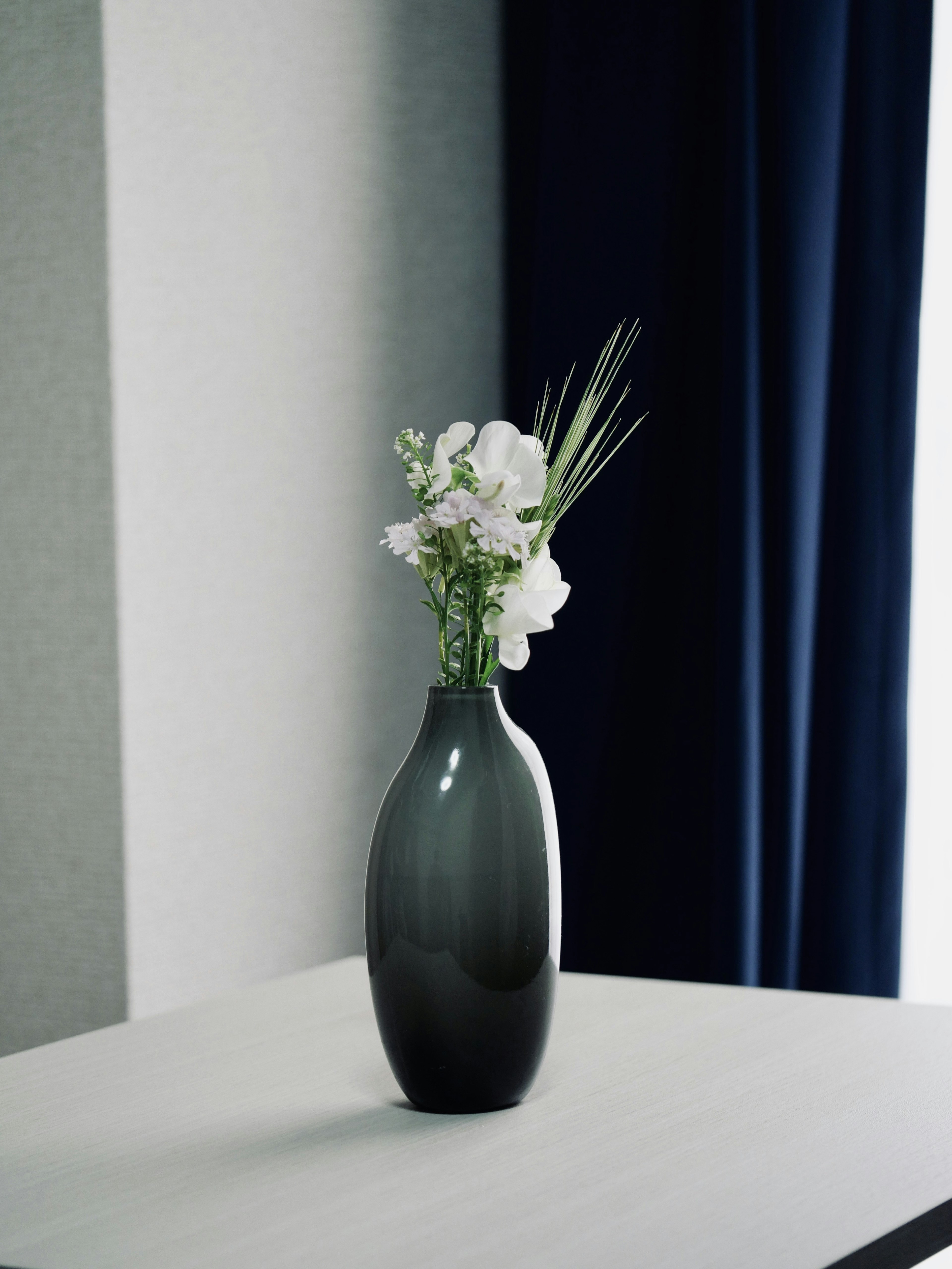 Simple interior featuring a black vase with white flowers