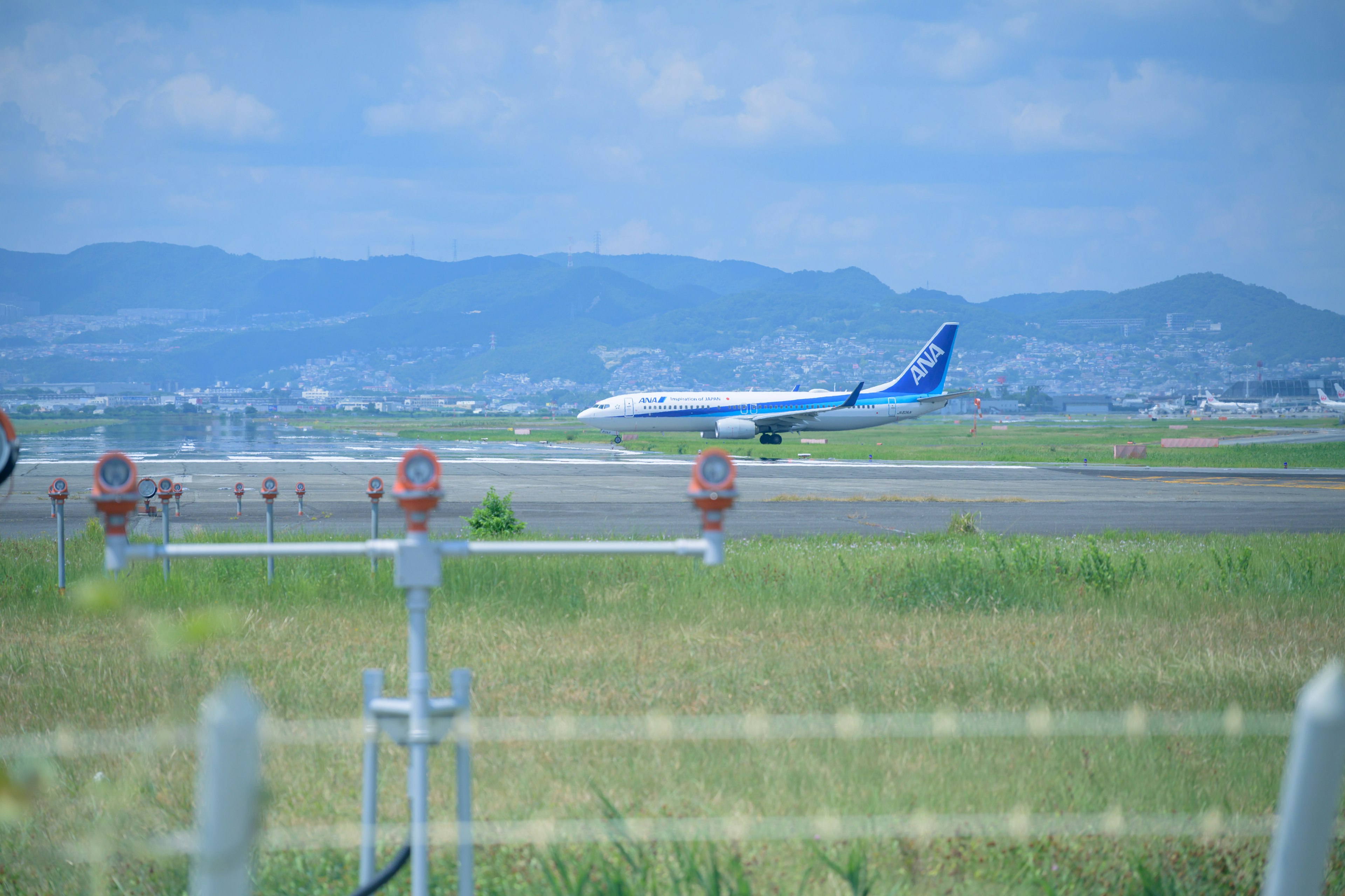 空港の滑走路に着陸する飛行機と青空の風景