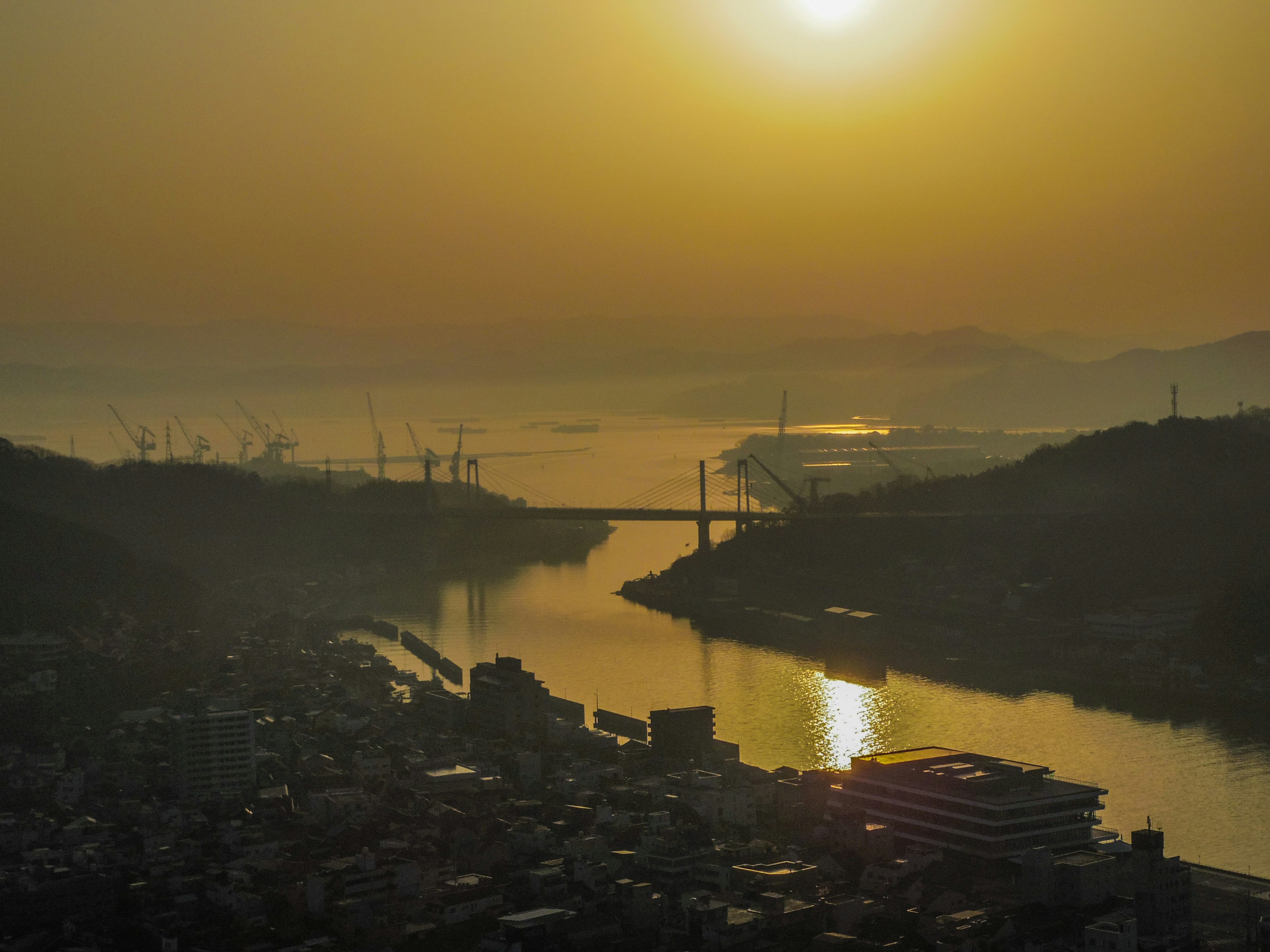 Vista panoramica di un fiume e un ponte al tramonto riflesso del sole sull'acqua