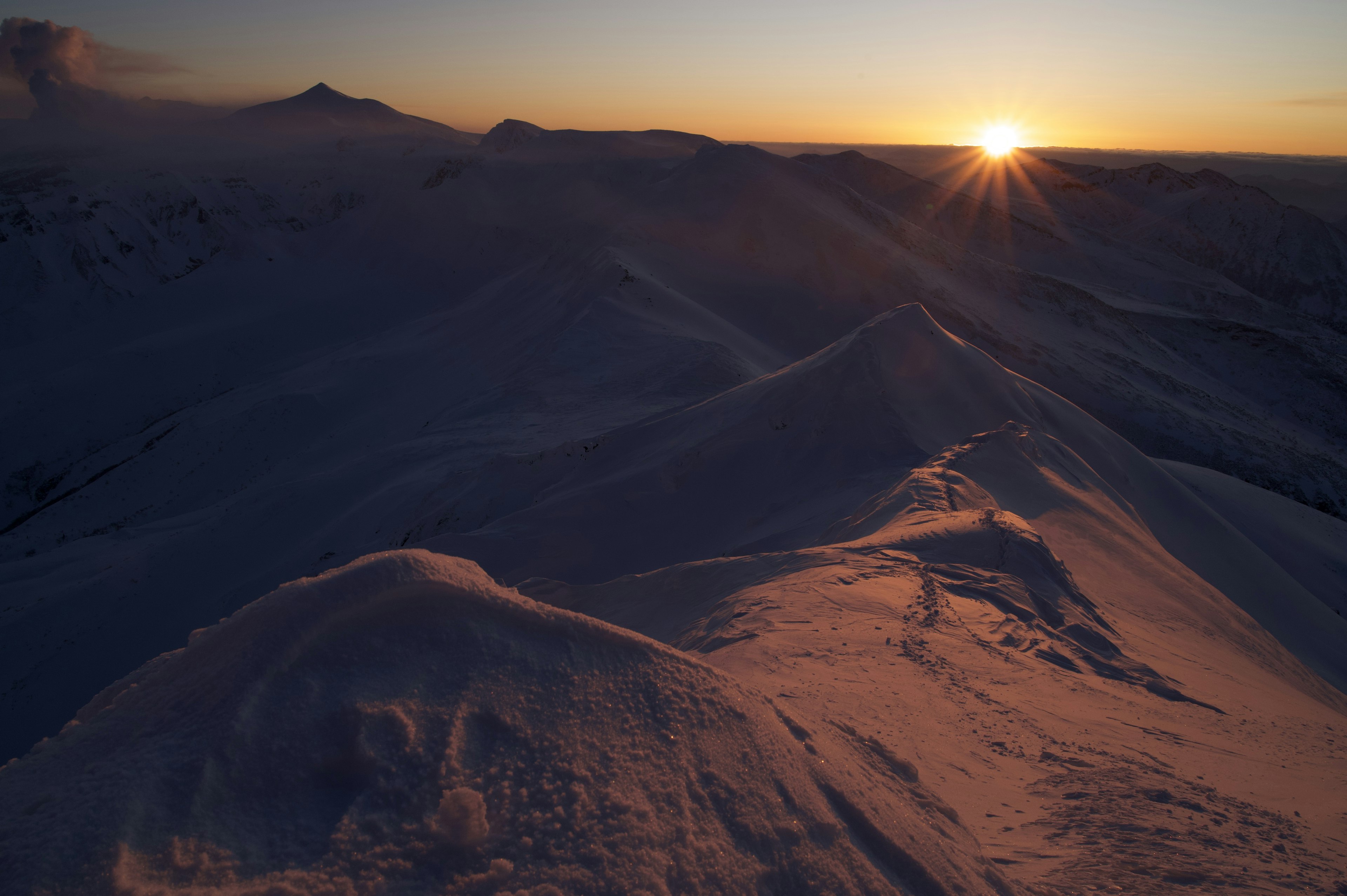 Montagnes enneigées avec un soleil levant