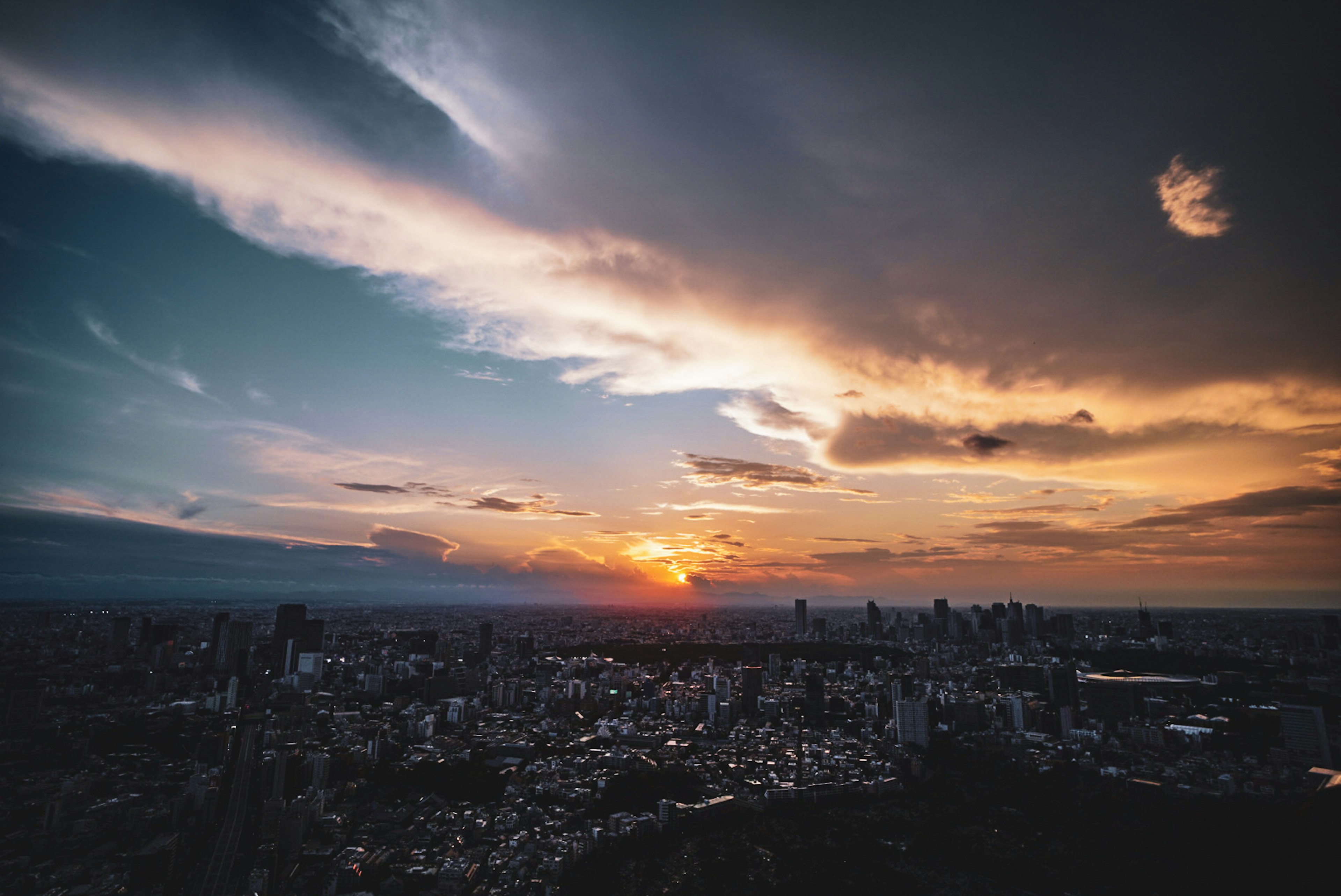 Paesaggio urbano al tramonto con grattacieli e nuvole drammatiche