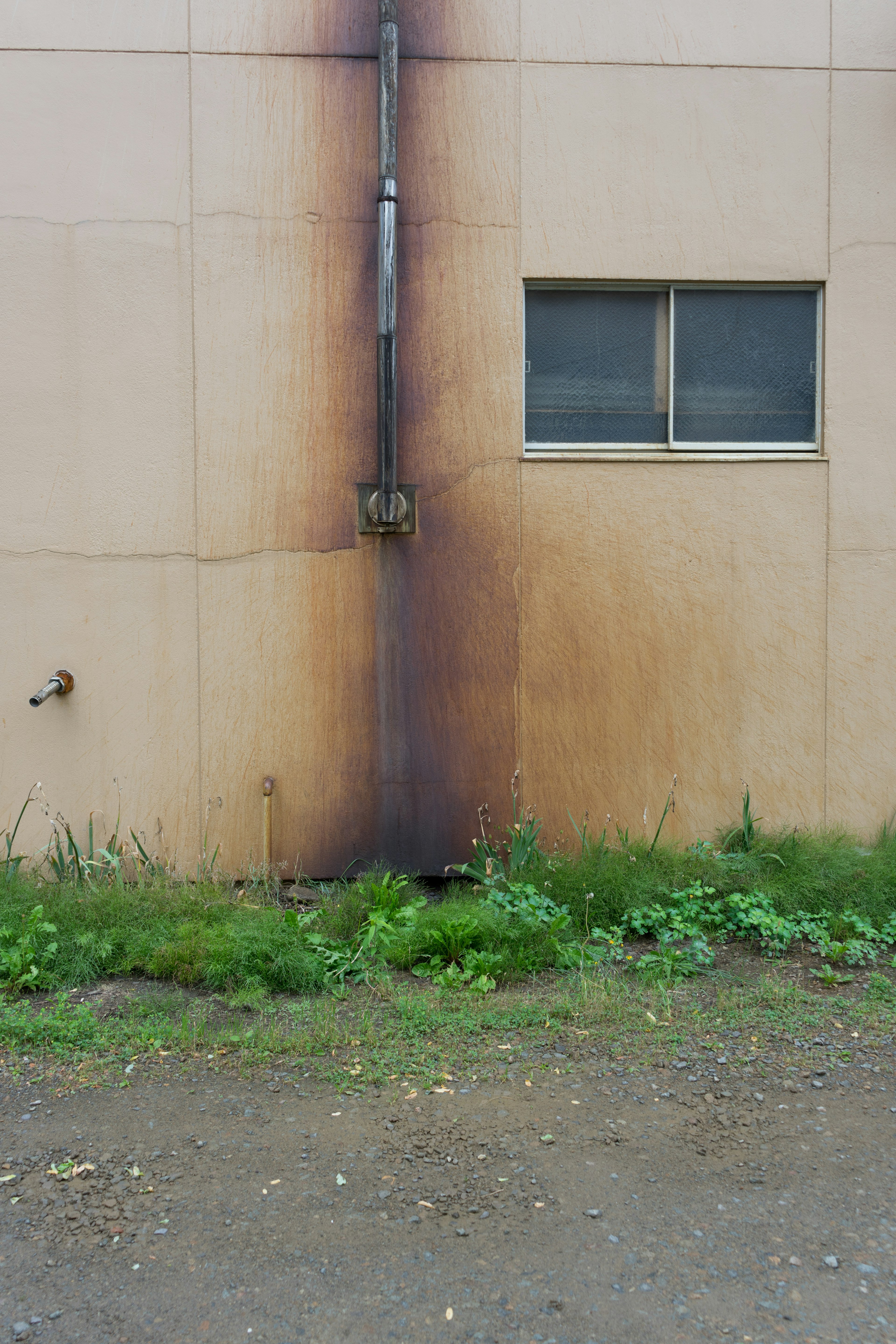 Exterior wall of a building showing smoke stains with a window