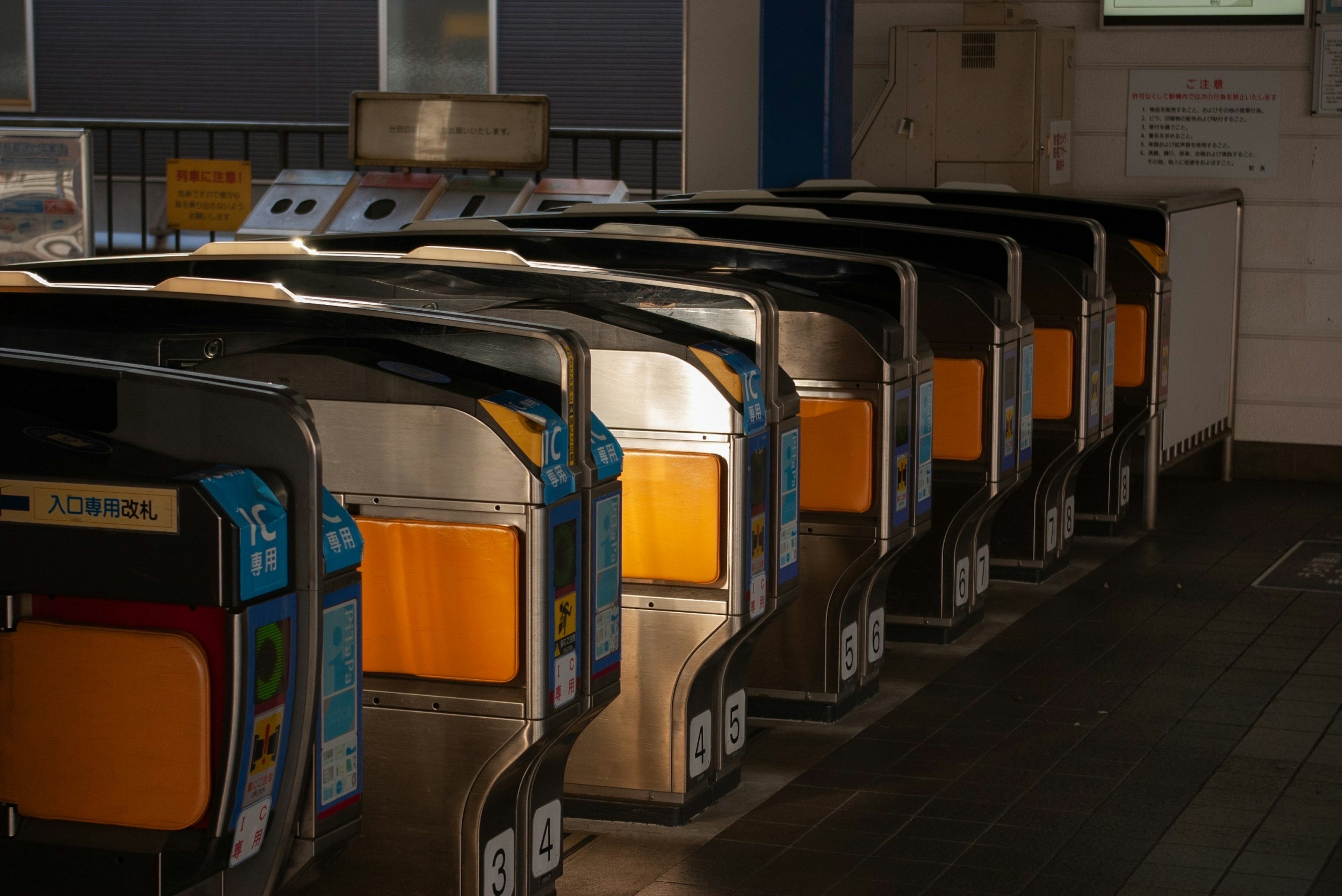 Vista interior de una estación de tren con torniquetes automáticos alineados