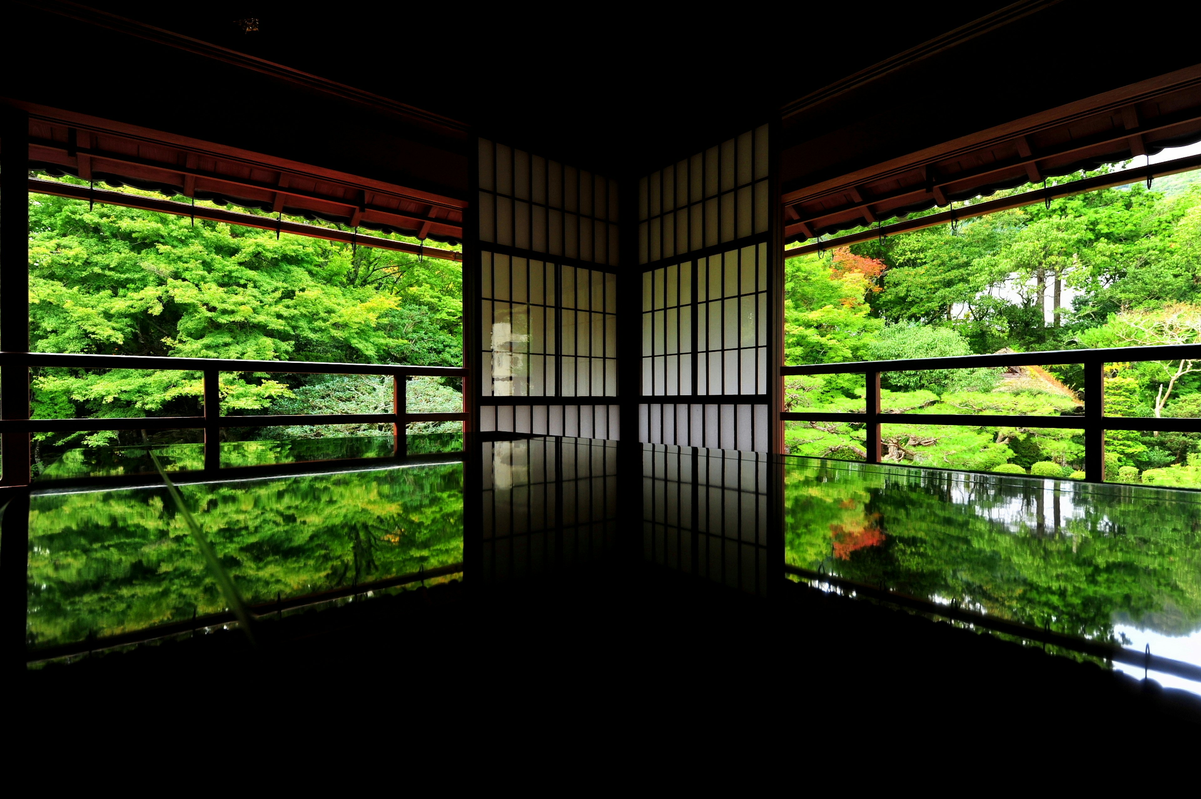 Quiet Japanese room with views of green landscape and water reflections