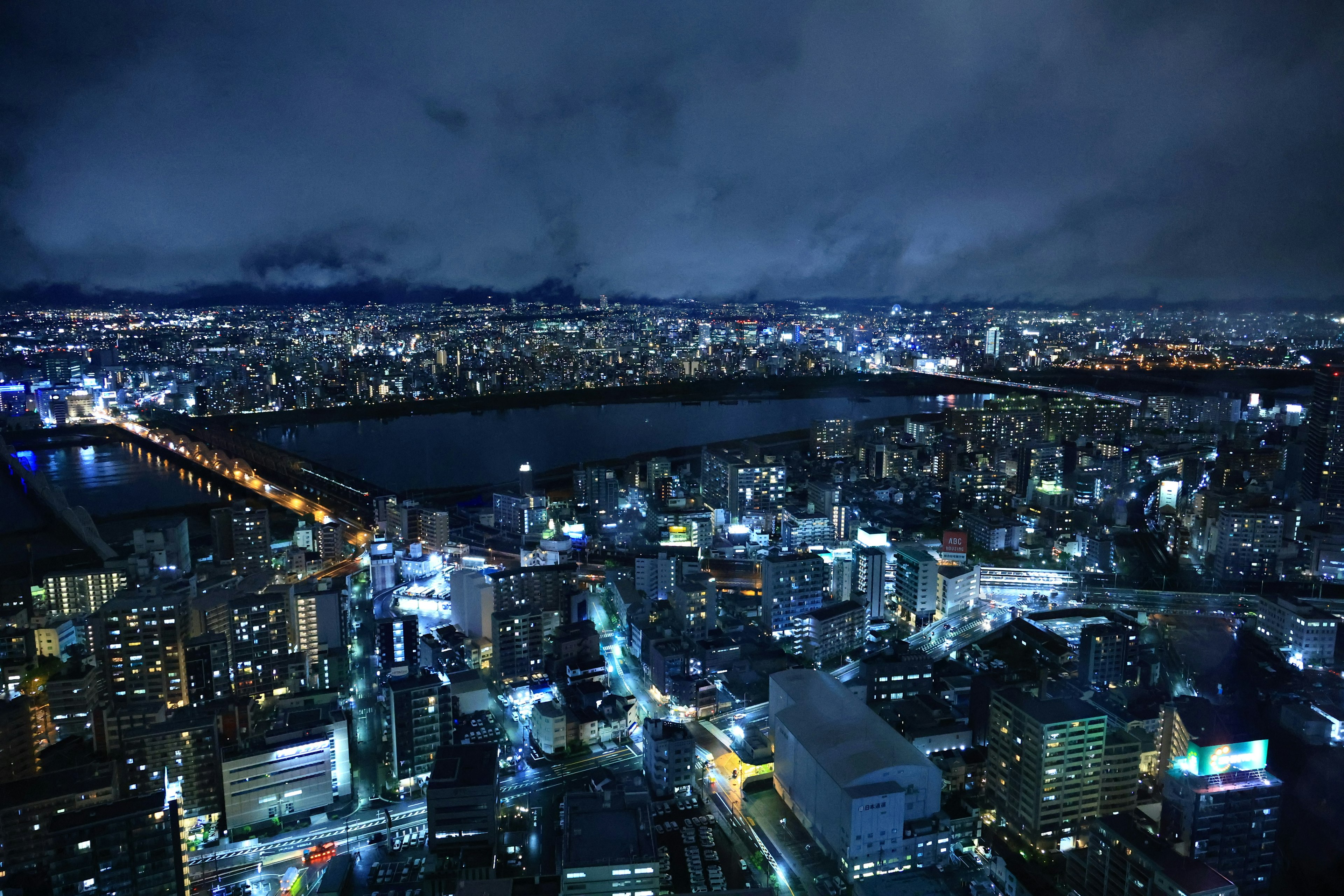 Night cityscape with illuminated skyscrapers and reflections on the river