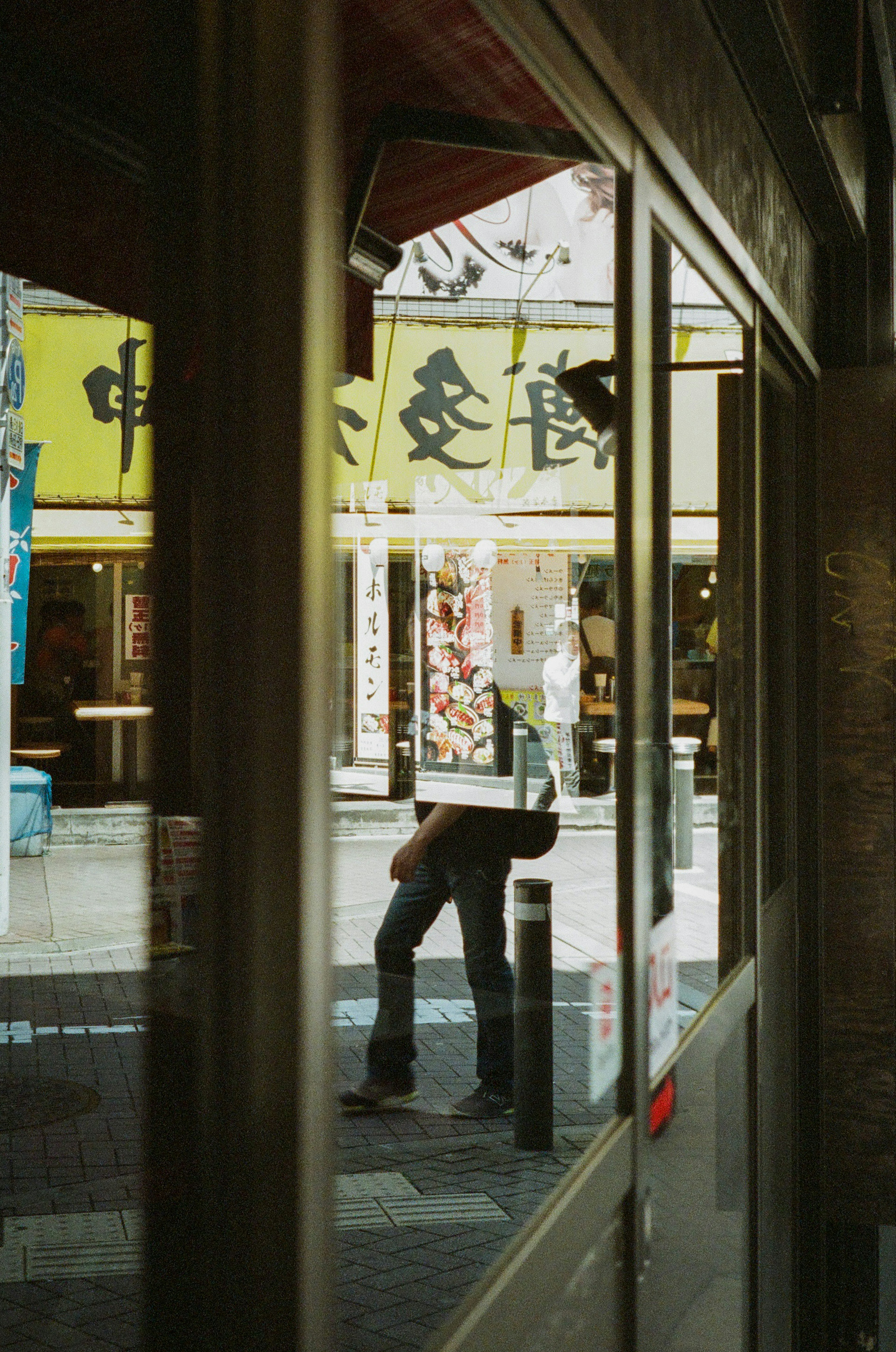 A scene reflecting a street view and a human silhouette through a window