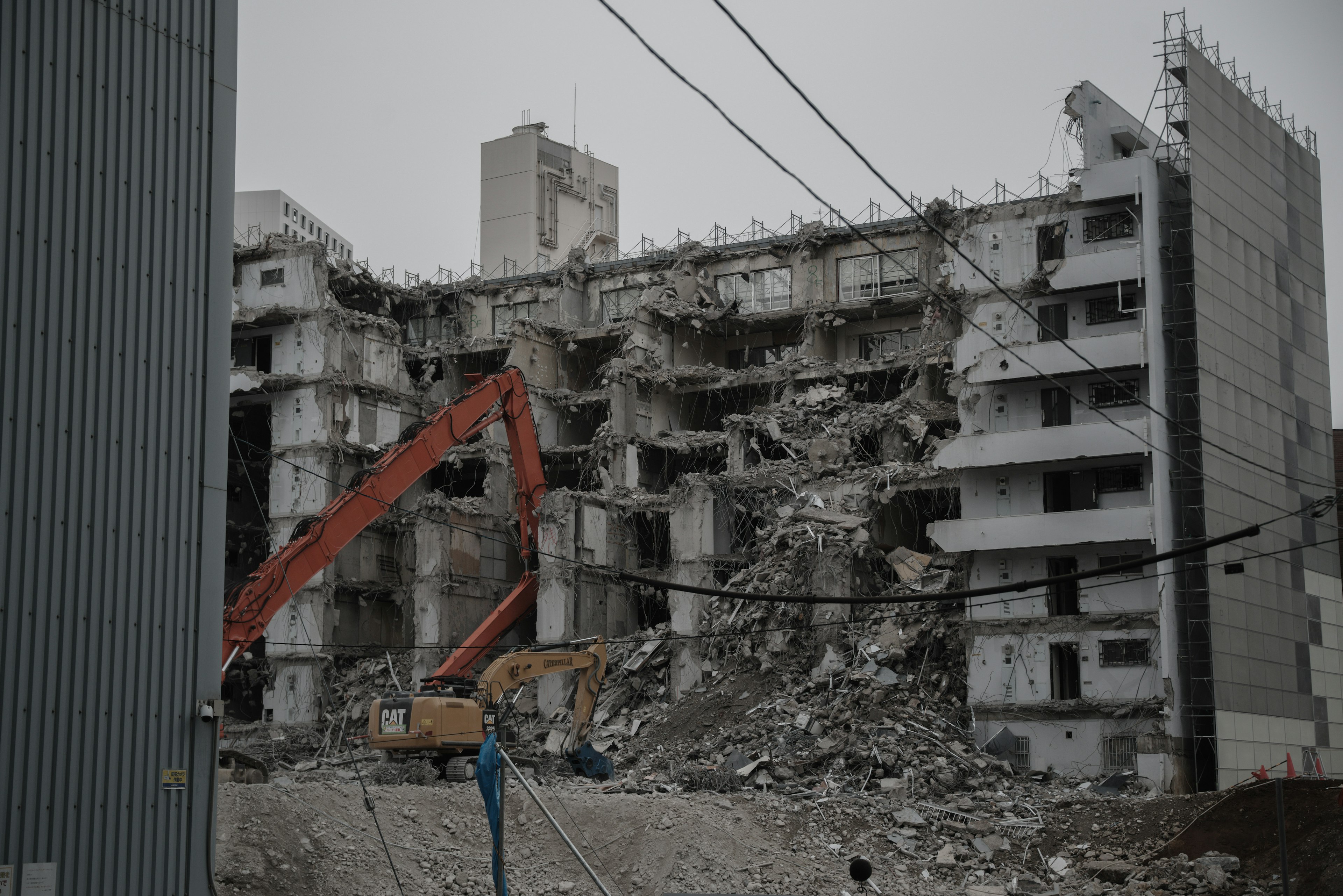 Demolition site with a partially collapsed building and heavy machinery