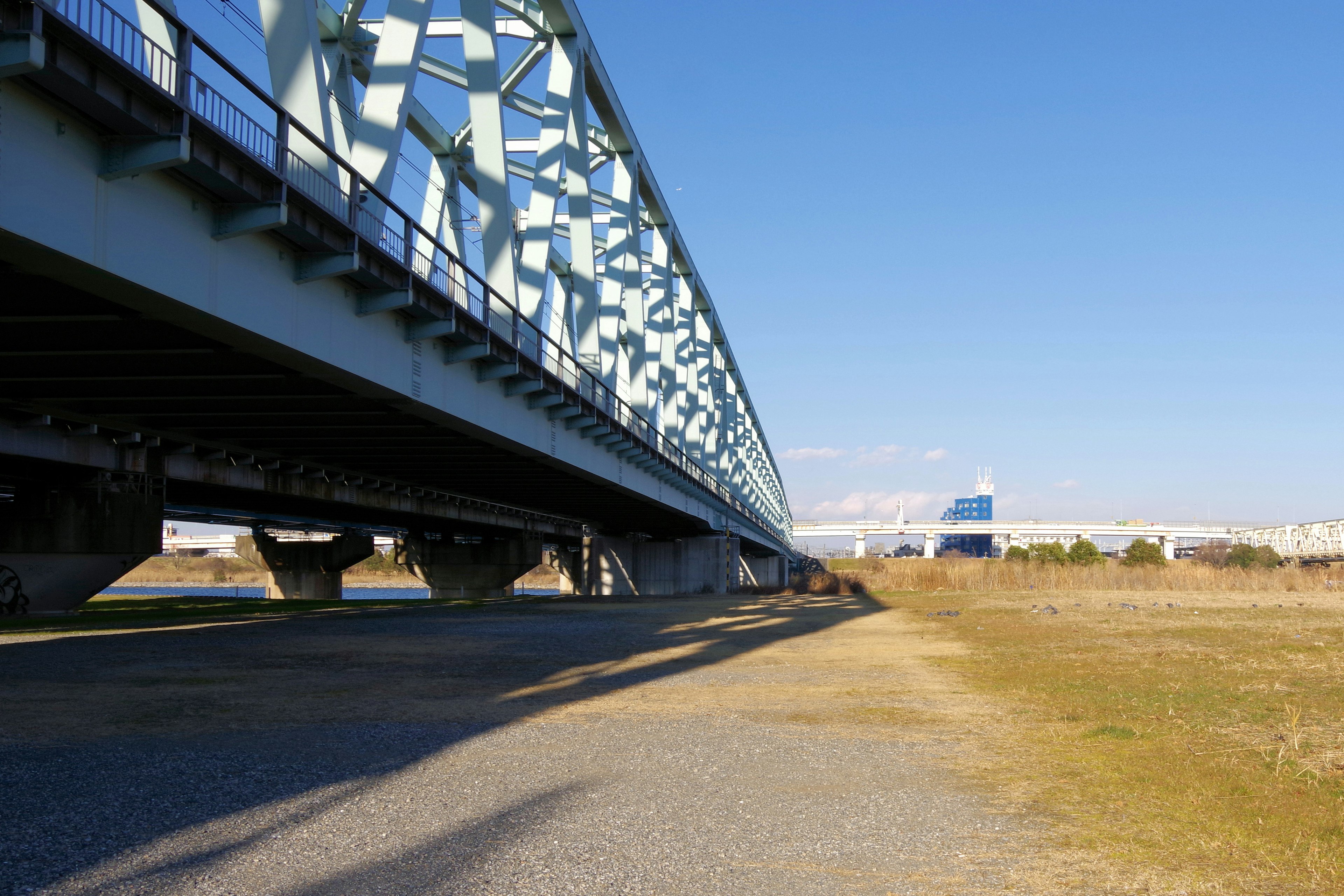 Vista da sotto un ponte con cielo blu chiaro che mette in risalto la struttura del ponte