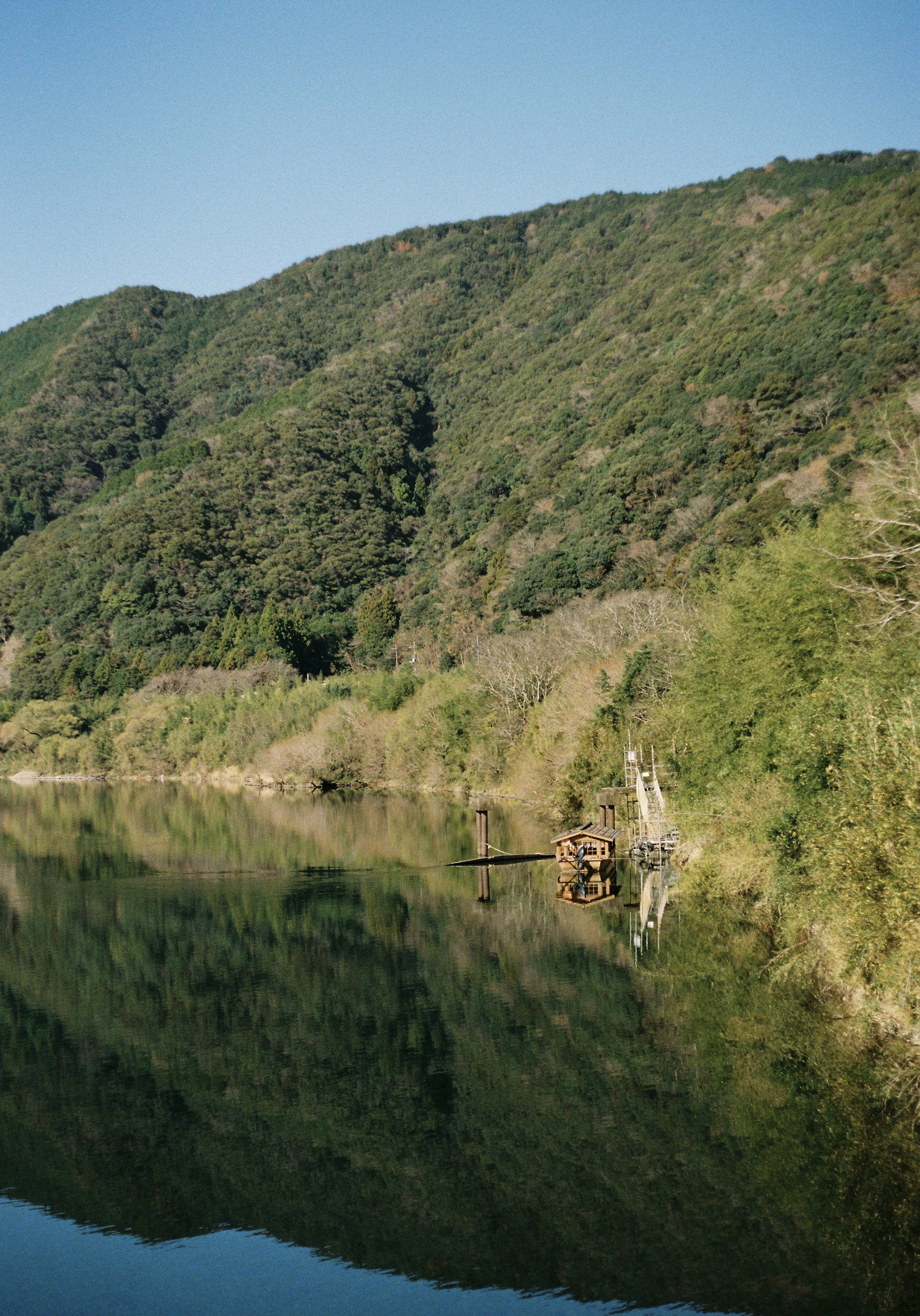 Paisaje fluvial sereno con montañas verdes reflejadas