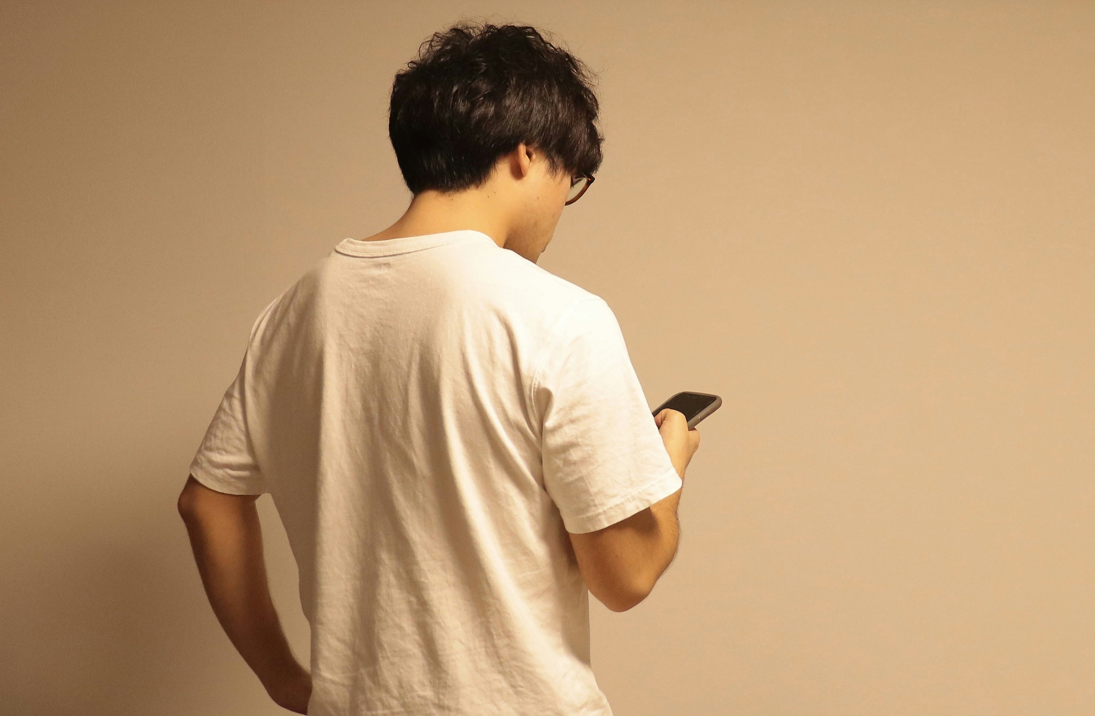 Man using smartphone while facing away