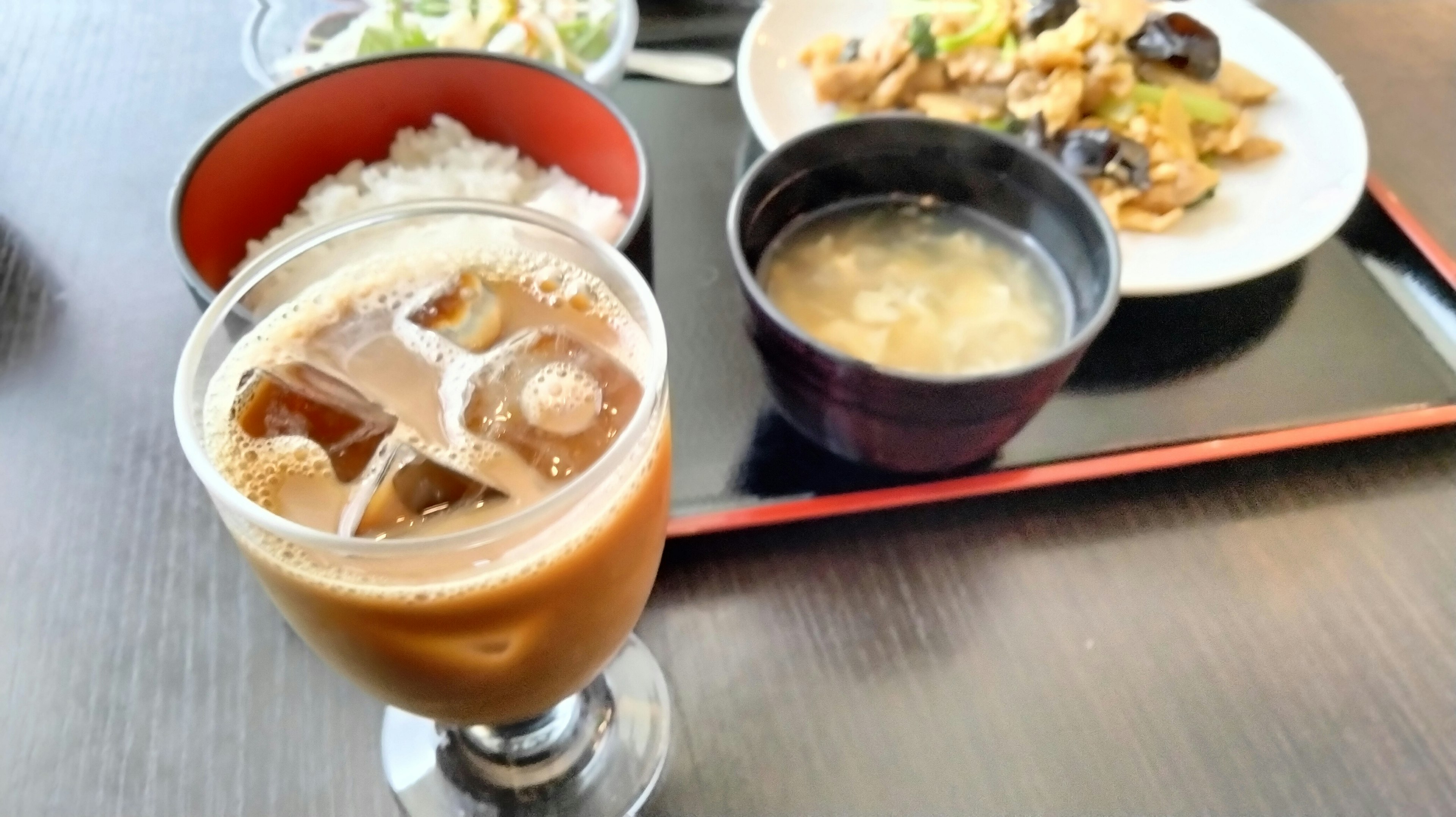 Café helado y un conjunto de comida japonesa en una mesa