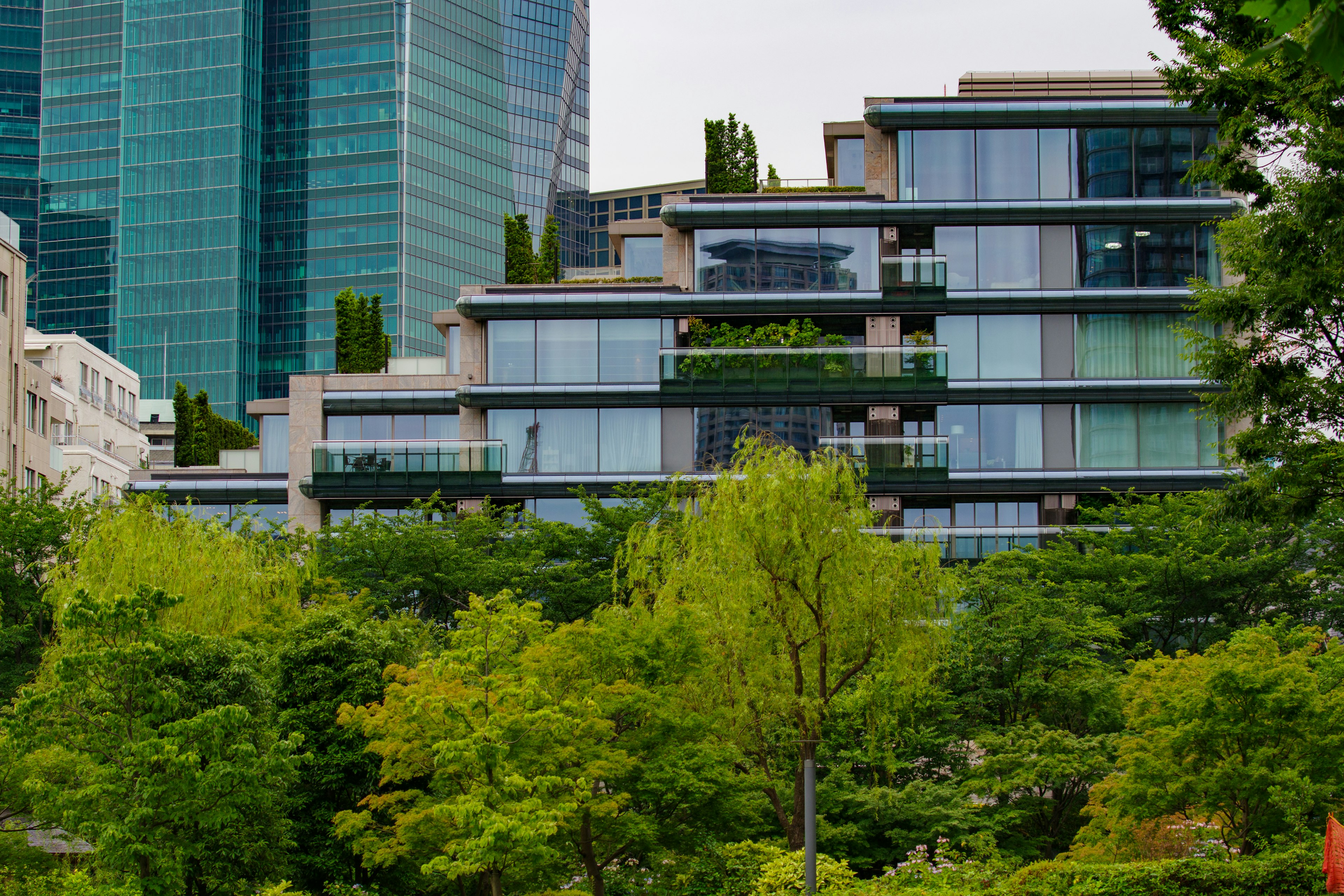 Complejo de edificios modernos rodeado de vegetación con rascacielos al fondo