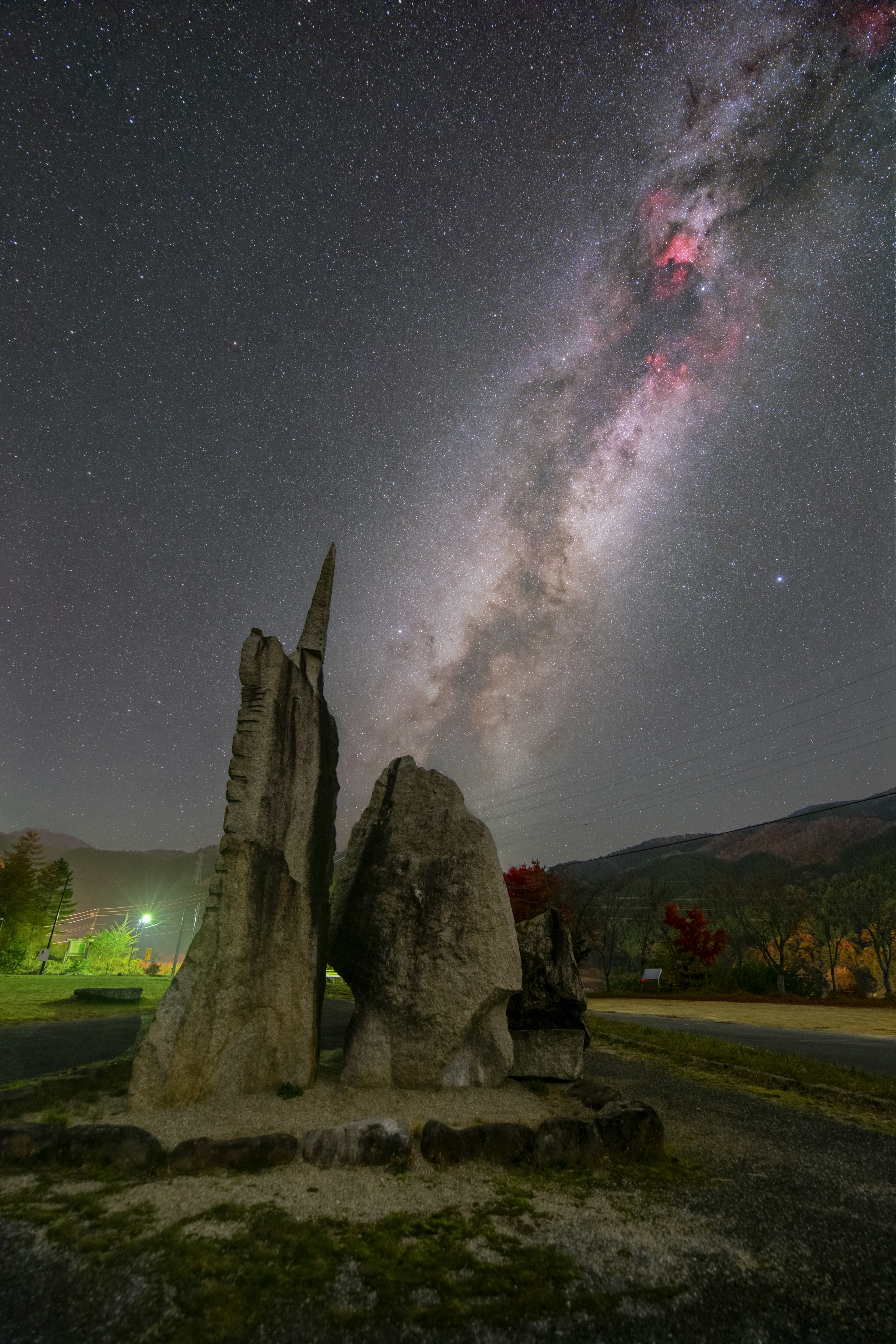 夜空に輝く天の川と岩のモニュメントが特徴的な風景