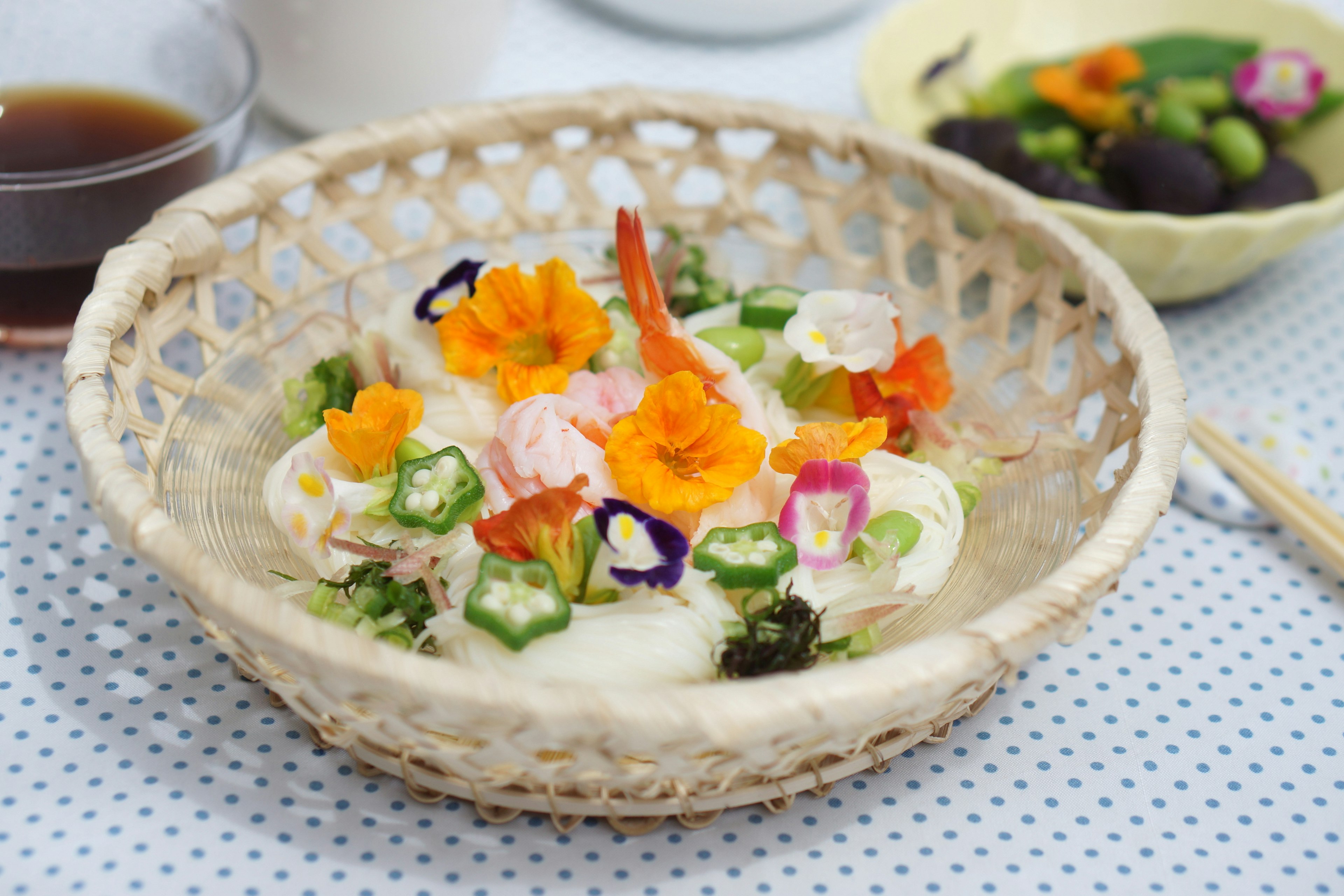 A beautifully plated Japanese noodle dish topped with edible flowers