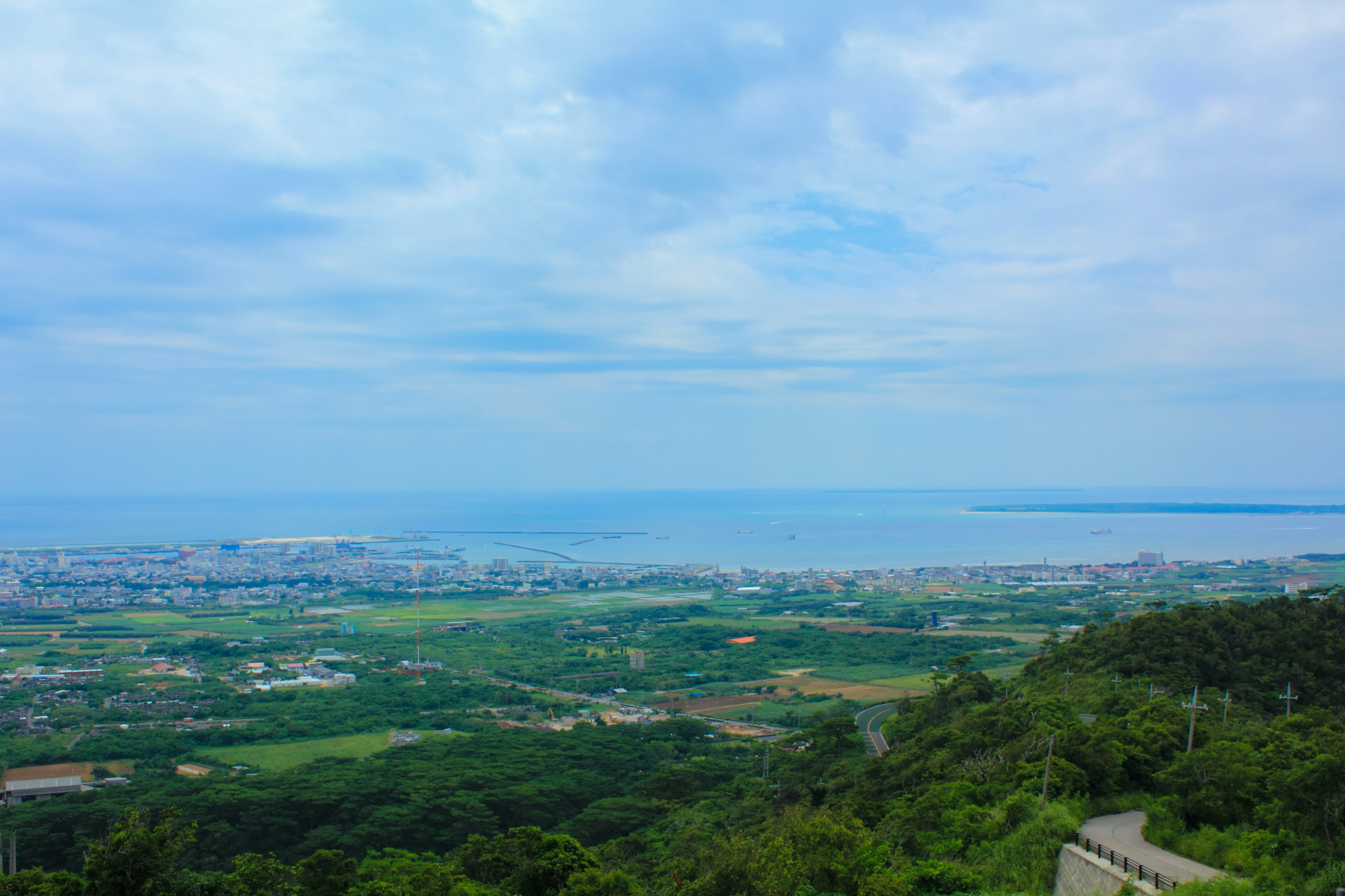 Scenic view of blue ocean and lush green landscape