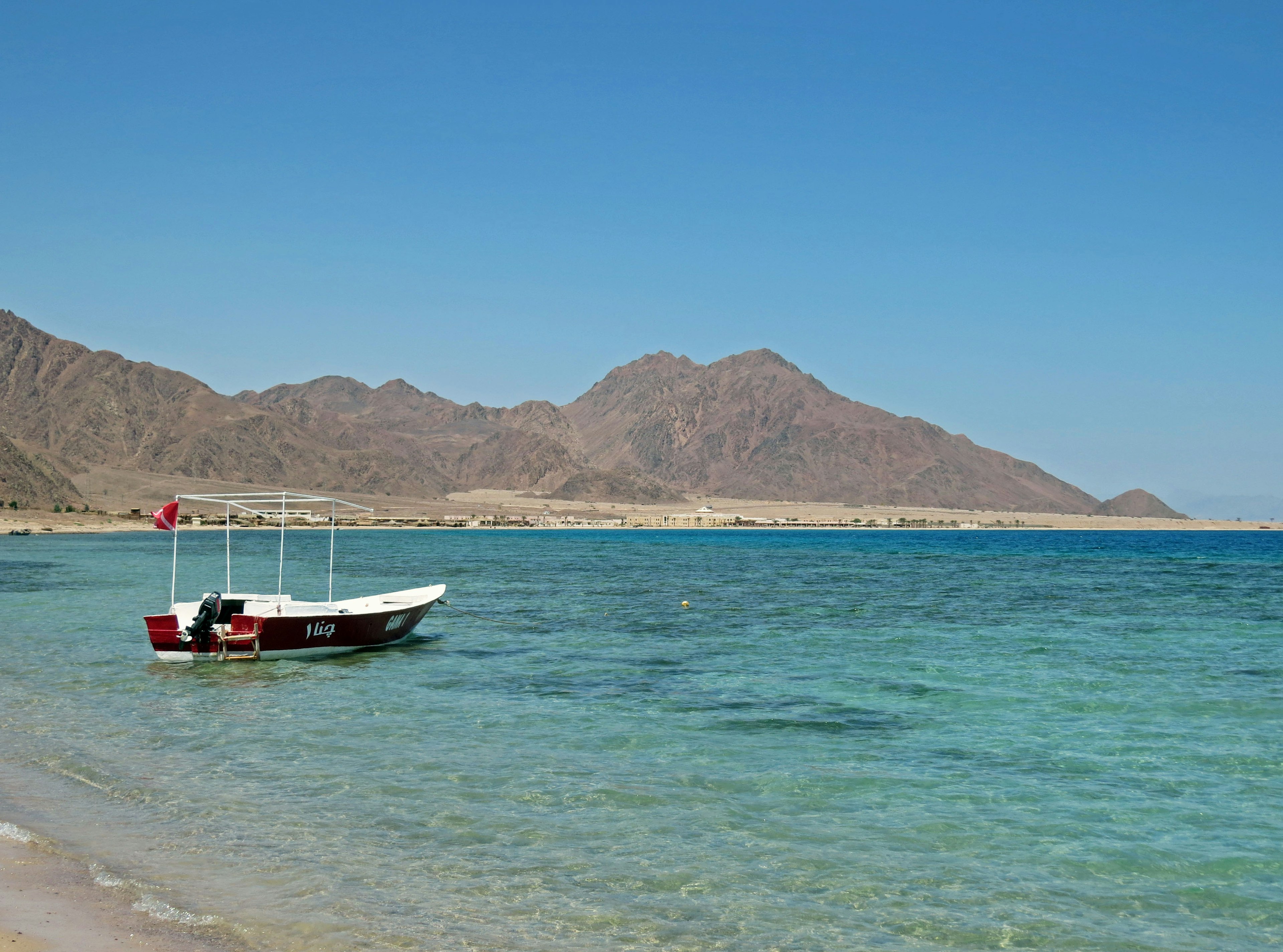 Scène de plage sereine avec un petit bateau et des eaux claires