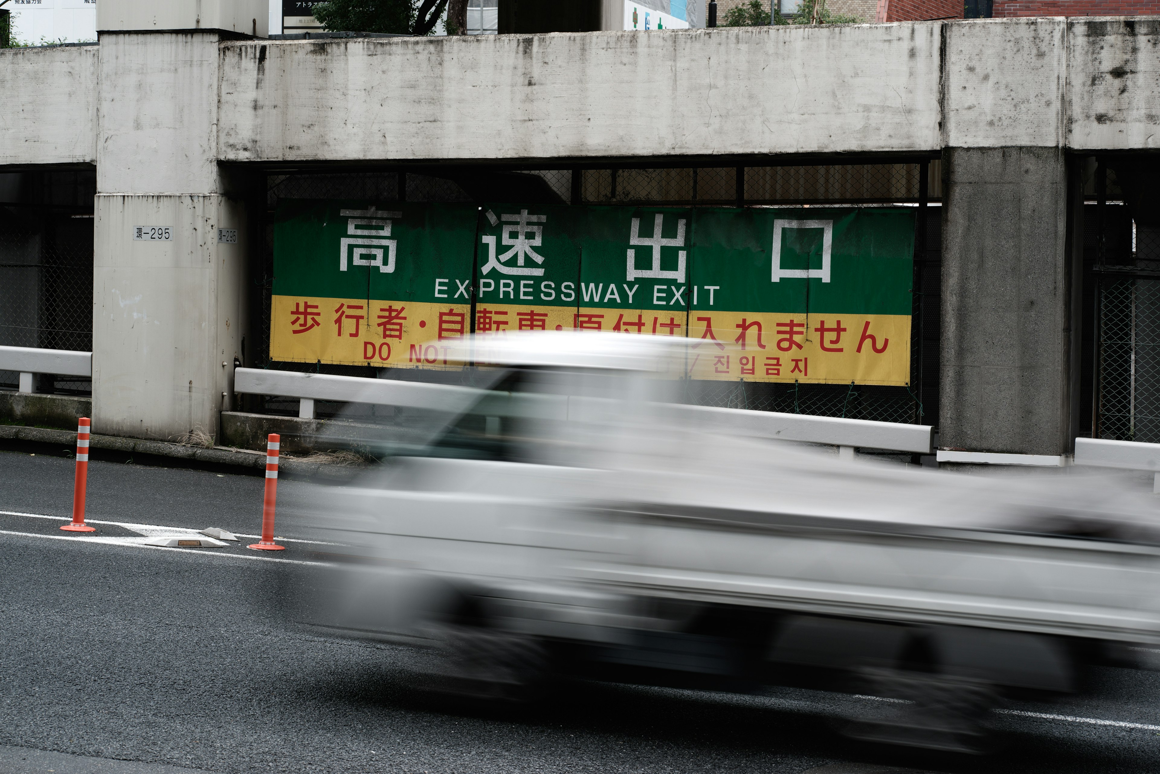 Scène urbaine avec un panneau de sortie d'autoroute et un camion en mouvement