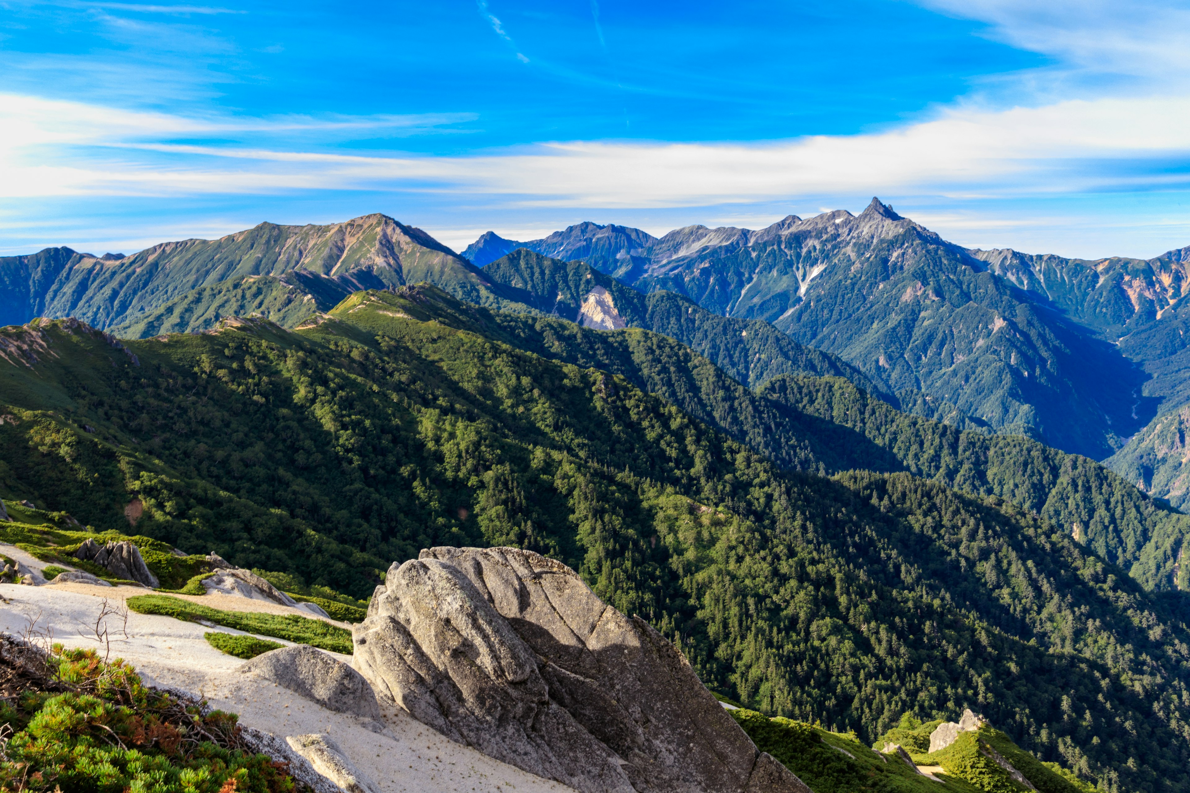 Eine malerische Aussicht auf grüne Berge unter einem blauen Himmel