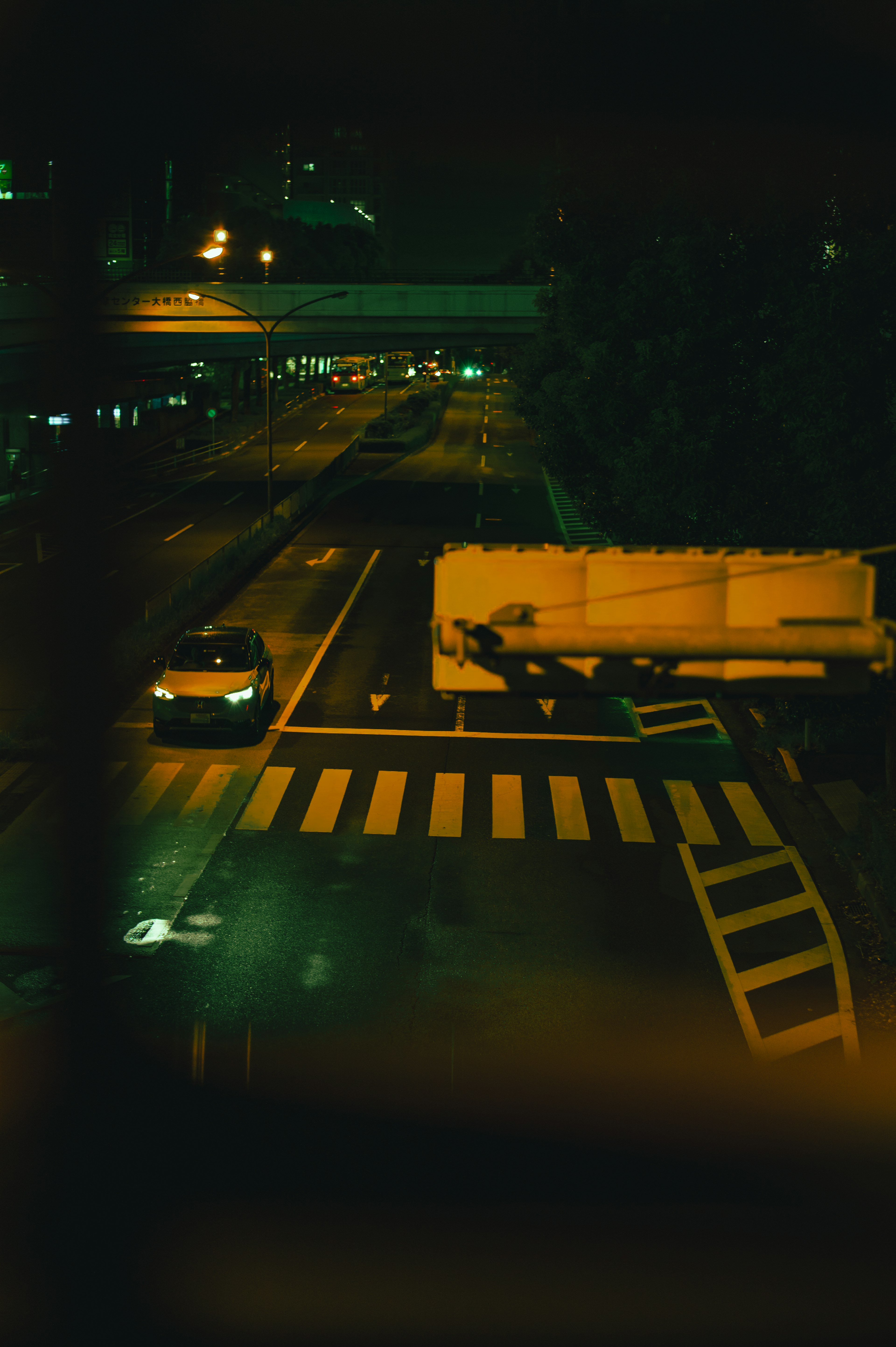 A parked car and truck at a city intersection at night