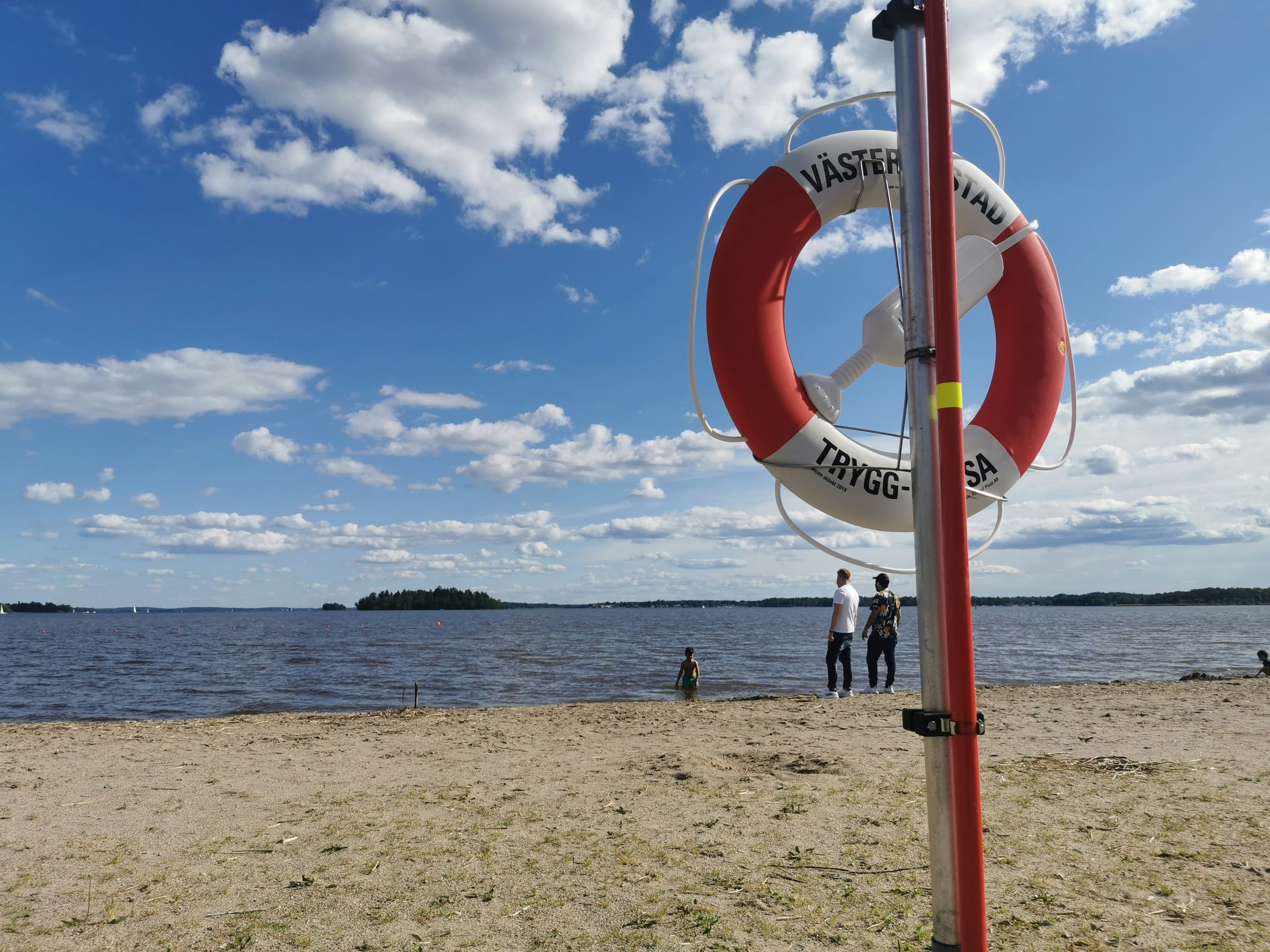 Lifebuoy on the beach with people in the background