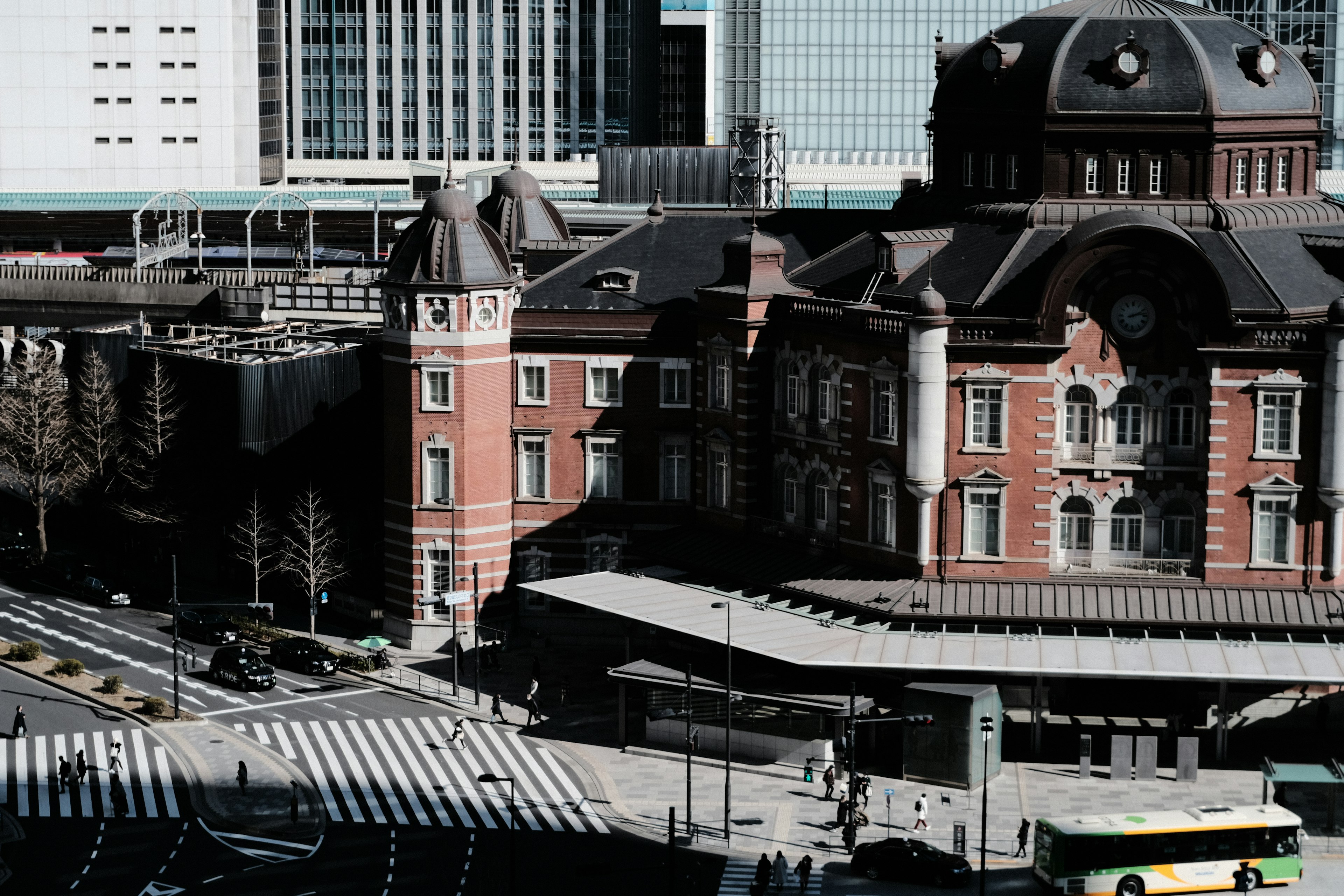 Die schöne Fassade des Tokyo Bahnhofs mit umliegenden modernen Gebäuden