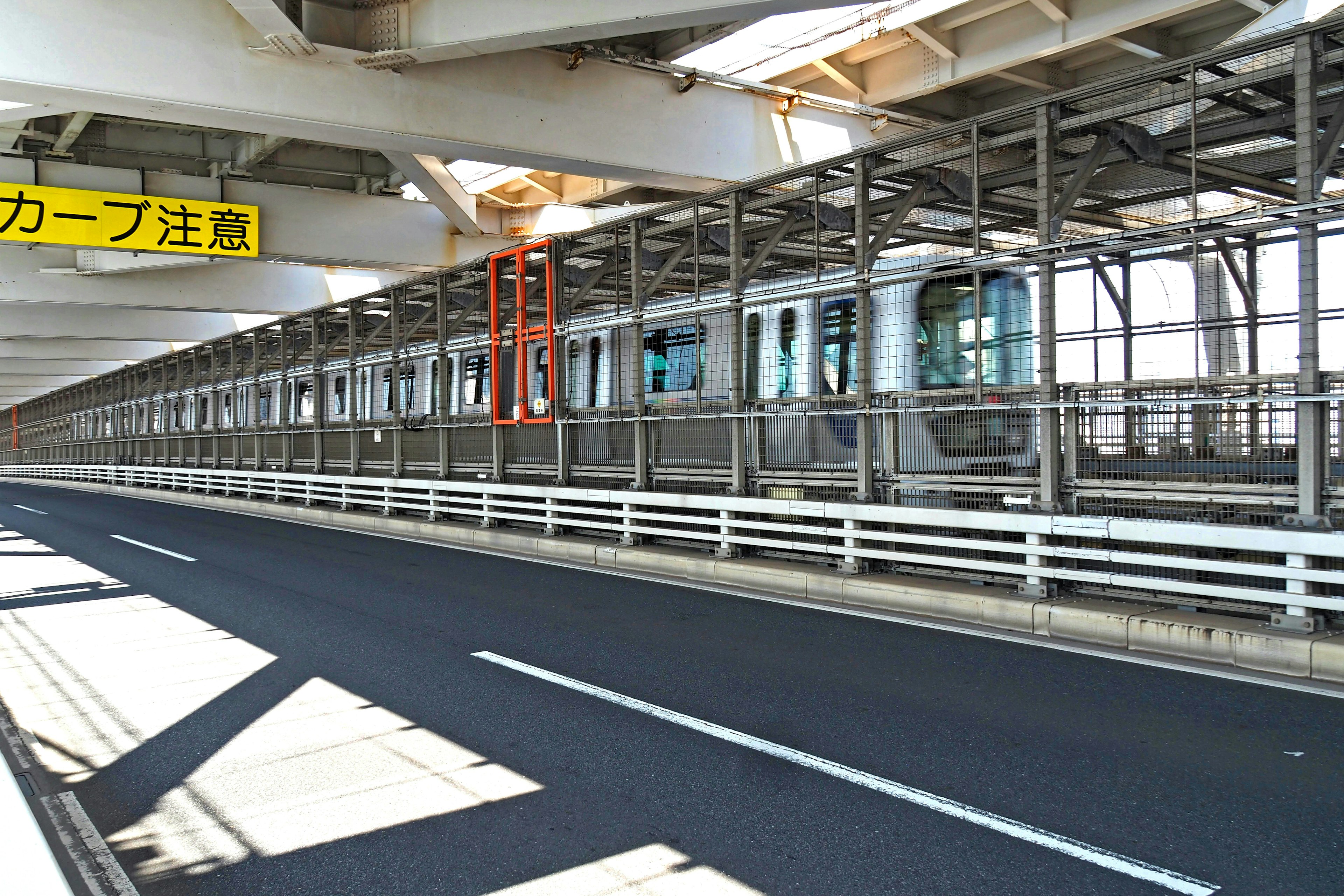 Vista di una strada sotto una ferrovia elevata con un treno